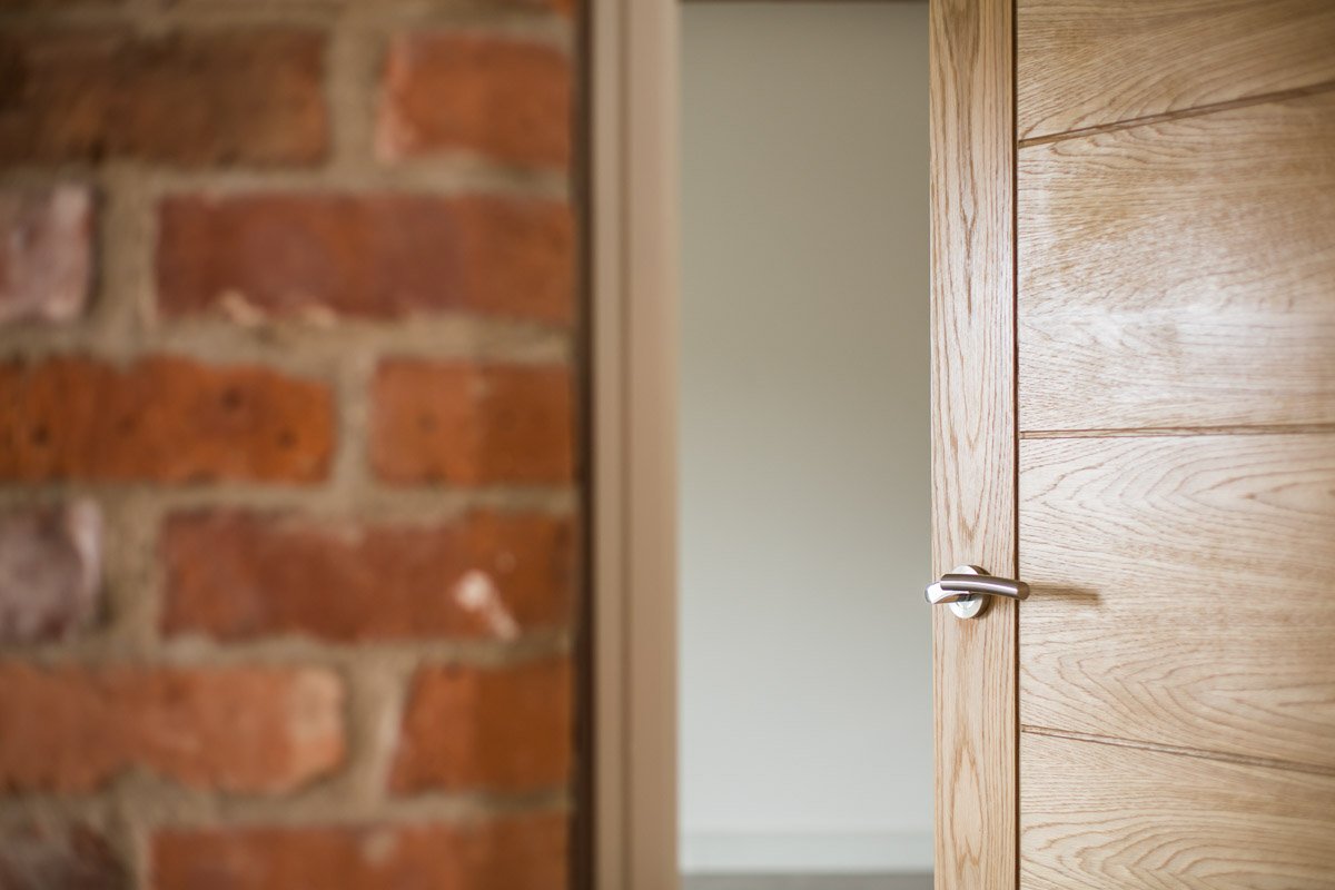 detail of wooden doors and bare red brick walls