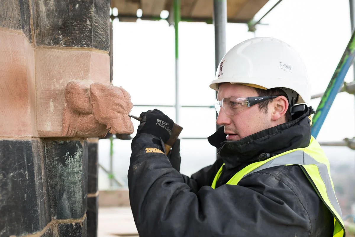 skilled worked chiselling detail into new sculpture 