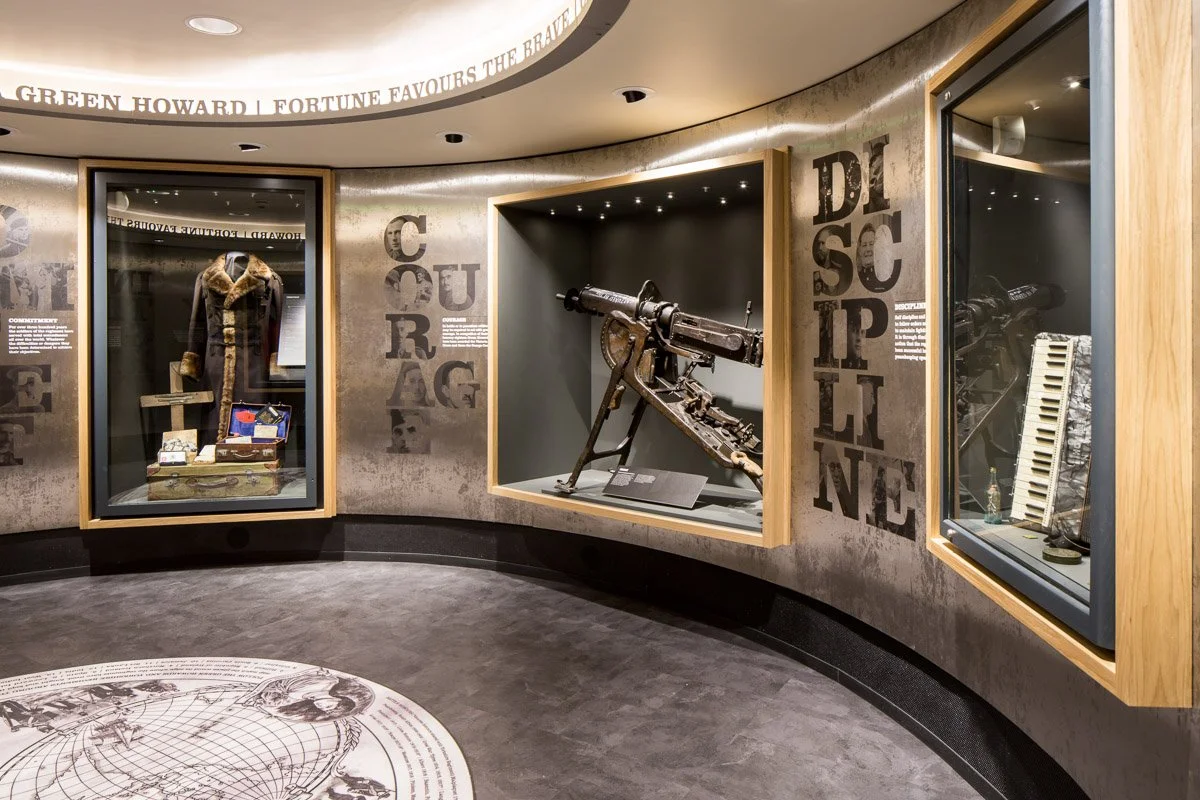 circular room in green Howards museum showcasing historical clothing and weaponry