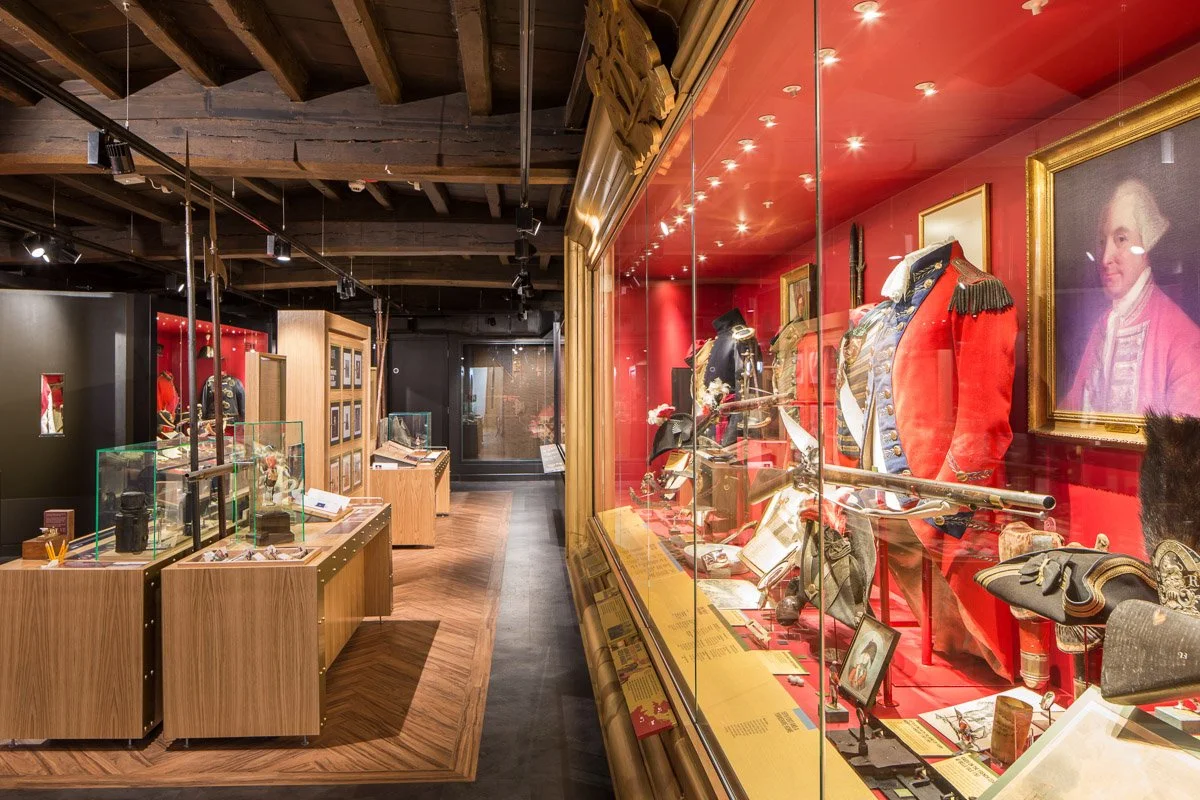 large room in green Howards museum showcasing historical war artefacts 