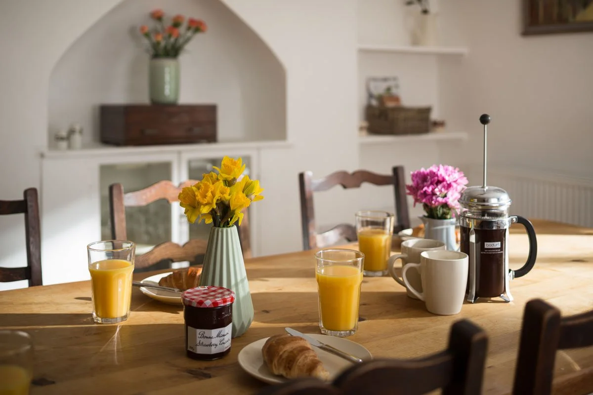 detail of dining table set up for breakfast with pastries, juice and coffee