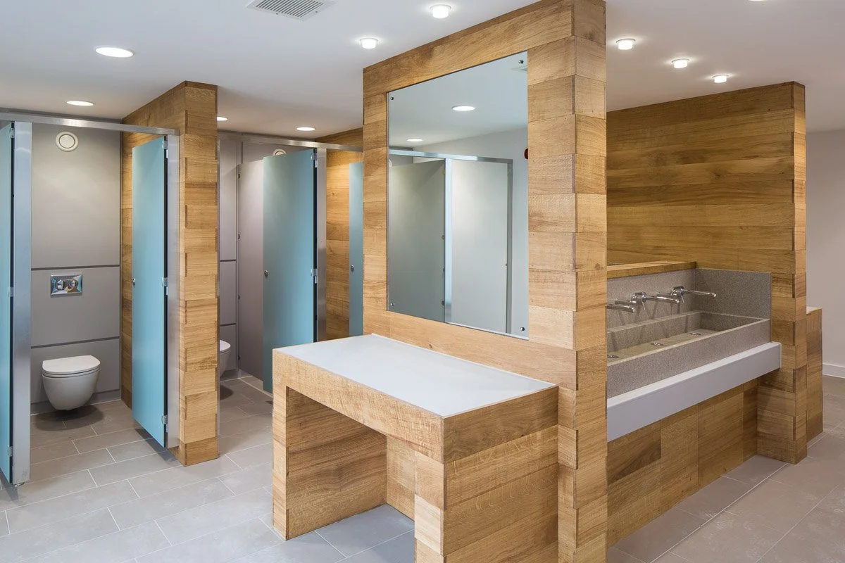 dunham massey visitor centre bathrooms, separate cubicles with frosted glass doors, large sink units surrounded by wood