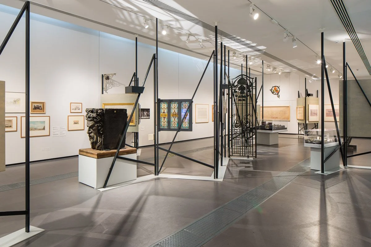 inside exhibit 'destination stations' several pieces of rail history under show lighting 