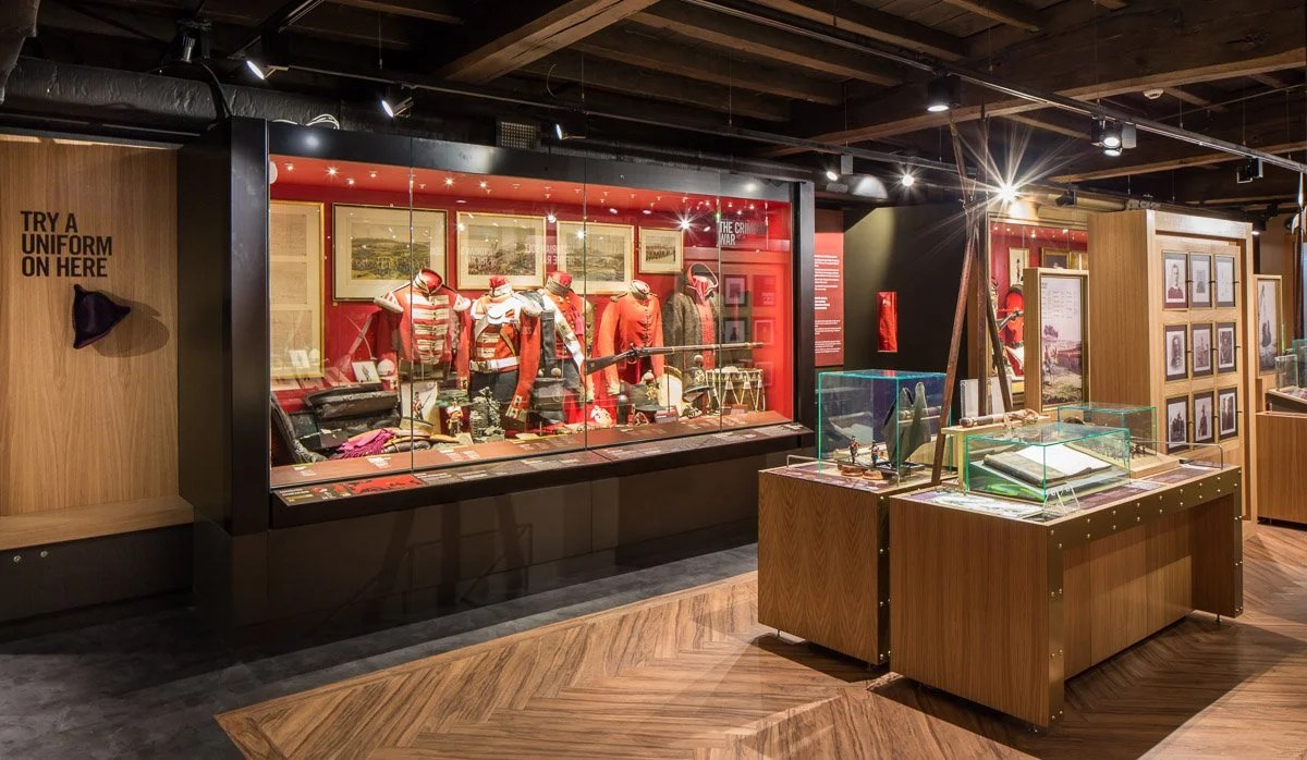 large room in green Howards museum showcasing historical war artefacts 