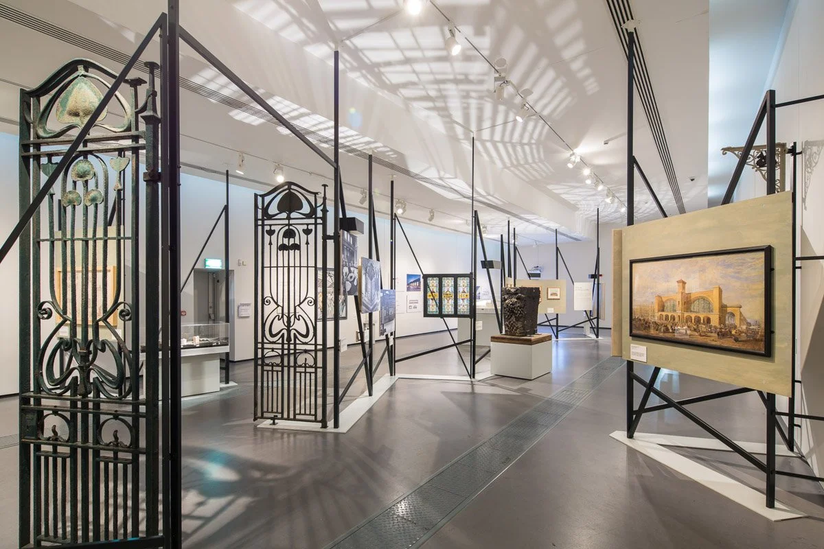 inside exhibit 'destination stations' several pieces of rail history under show lighting 