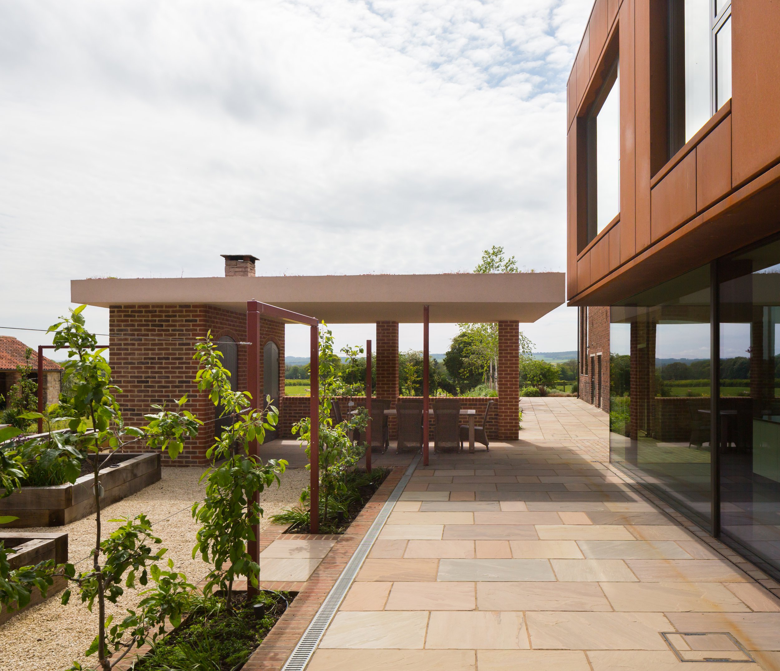 Outdoor kitchen area next to corten cantilevered first floor