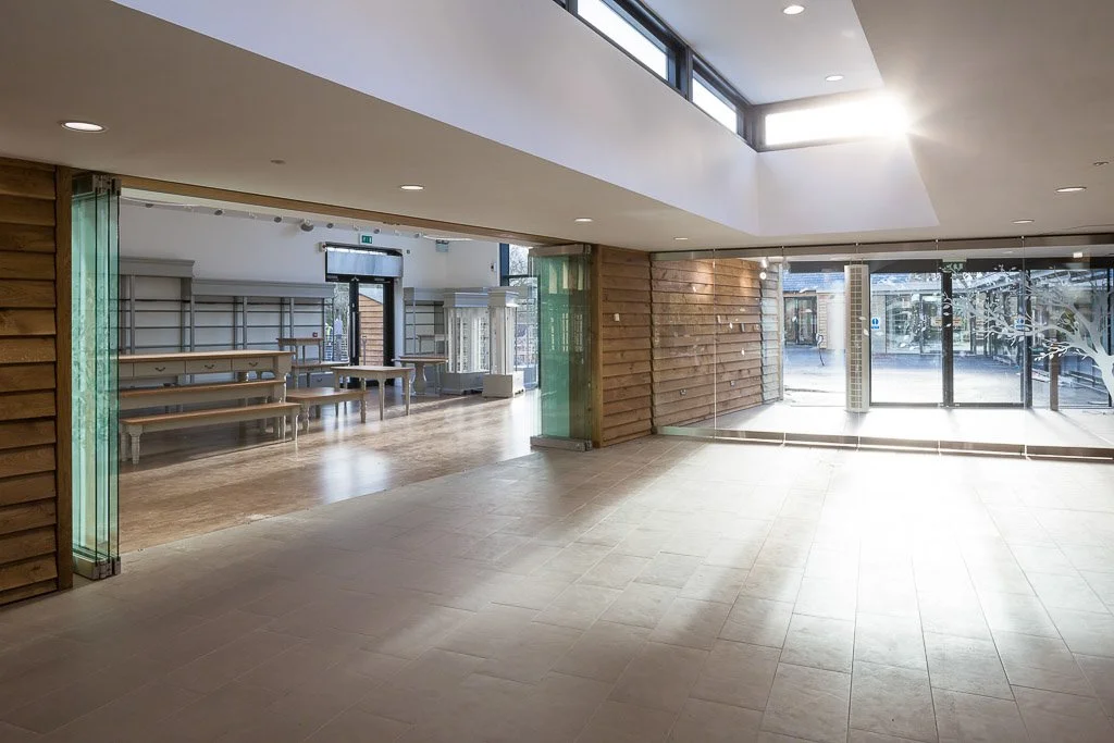 large open glass fronted unit with sky light, sun beaming in and tile flooring