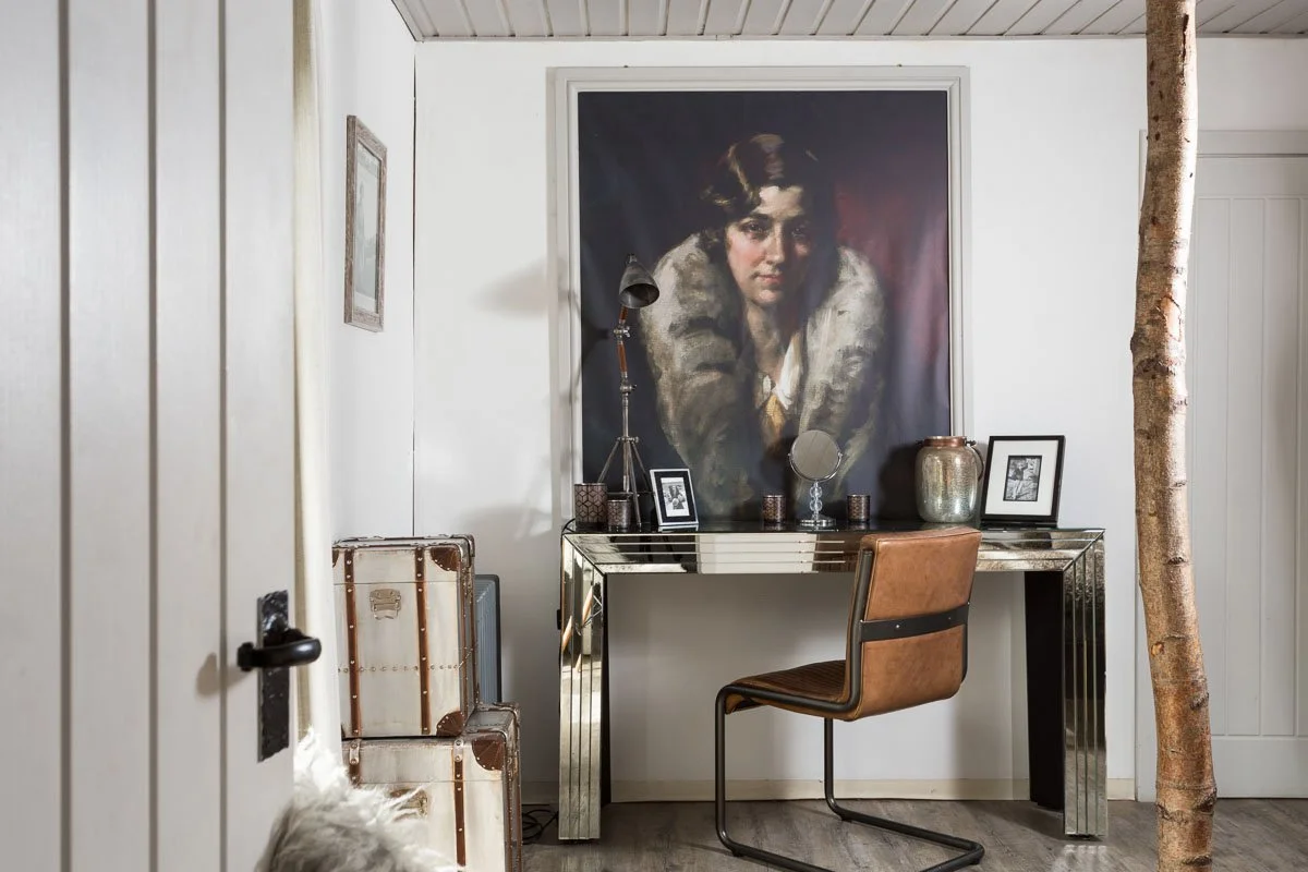 desk area with mirrored desk, modern leather chair, large painting on the wall