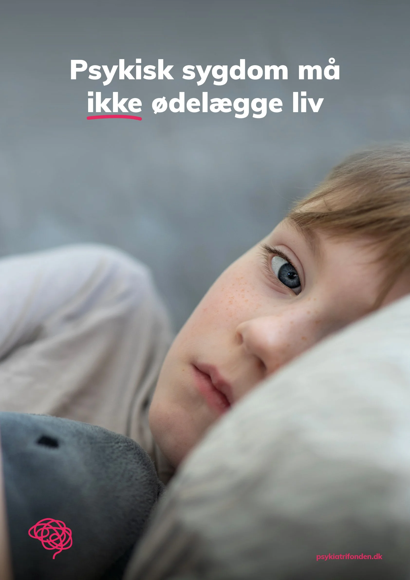 Close-up of a young child's face lying down on a pillow, with a focus on the child's blue eye and facial features, against a soft background.