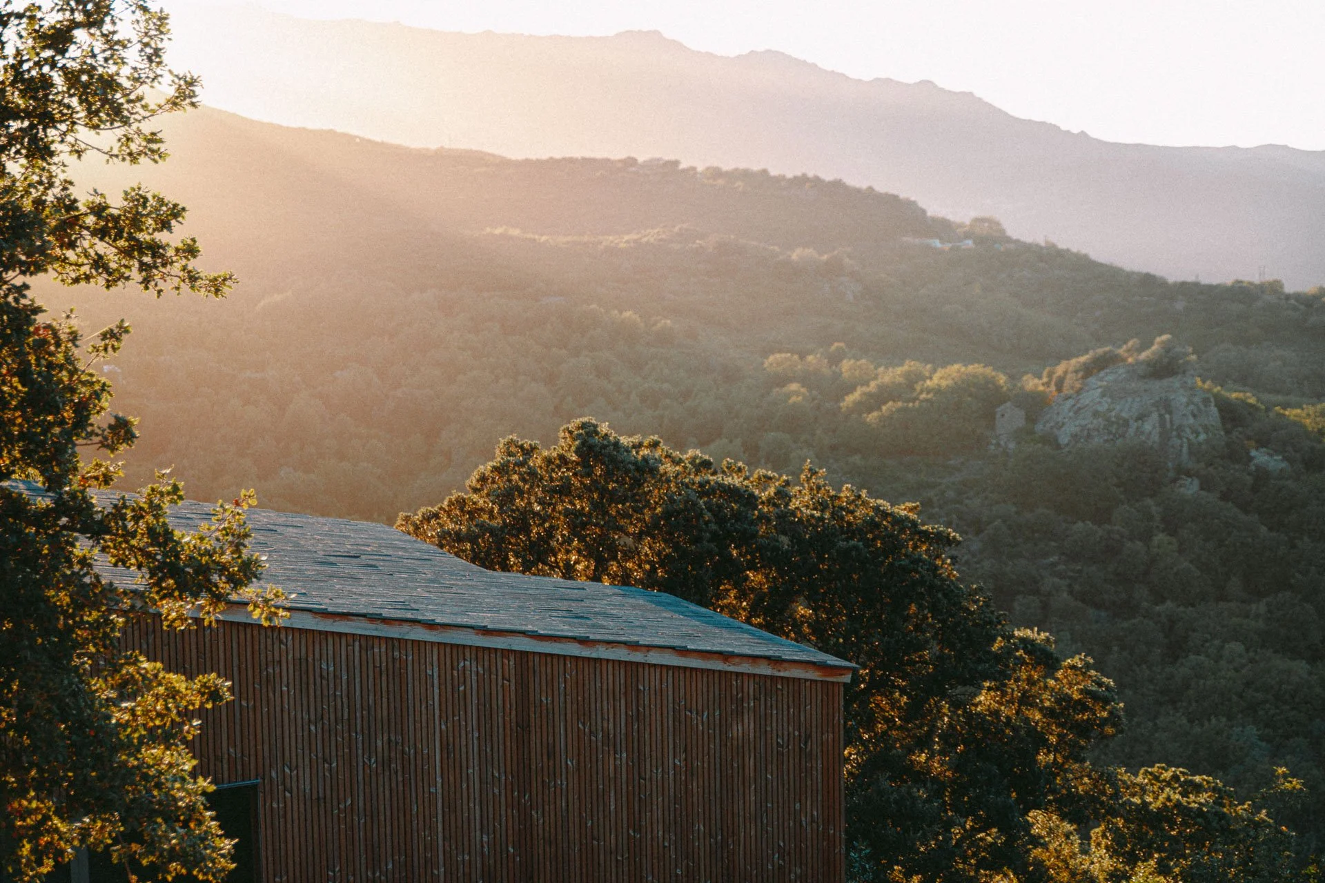 lumière rasante du matin sur la villa, atmosphère paisible et méditative pour commencer la journée de yoga et contemplation en Corse