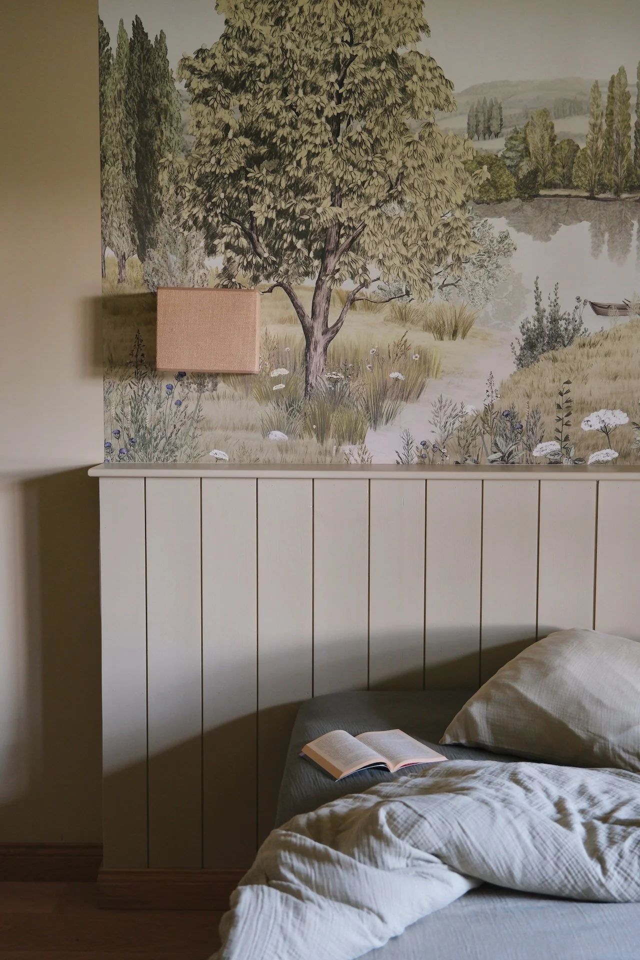 Tête de lit soignée, livre posé contre l'oreiller — le soin du détail et l'invitation à la lenteur dans une chambre de retraite bien-être à la campagne