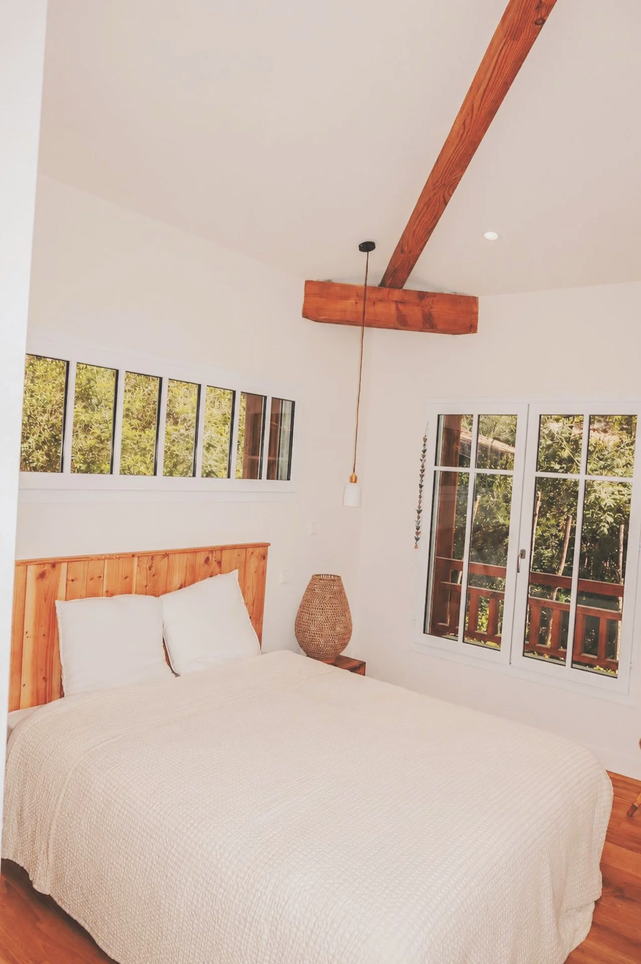 Chambre twin standard lumineuse, tête de lit en bois et fenêtres ouvertes sur la forêt landaise — confort simple d'une retraite yoga et surf