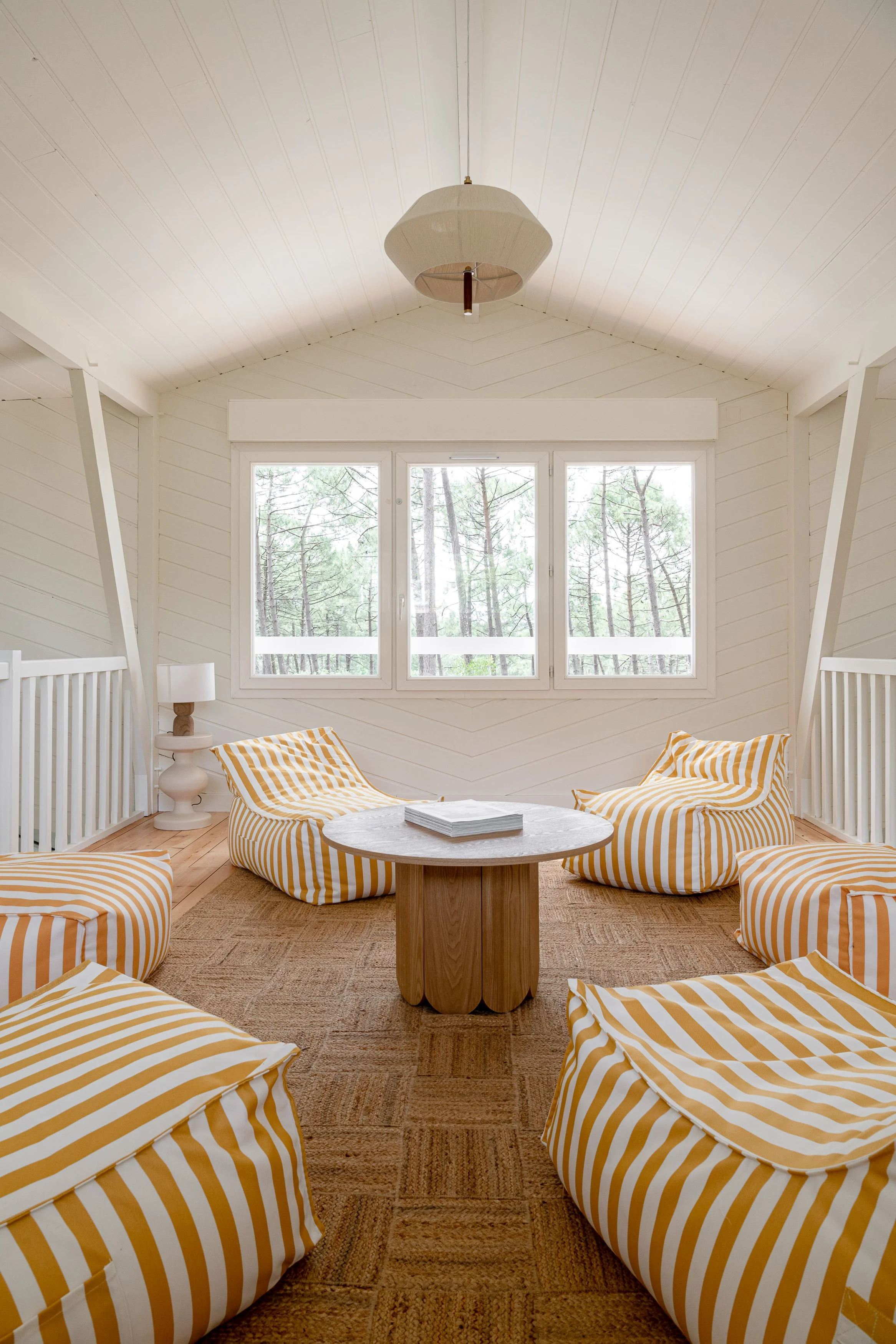 Un salon paisible sous les toits, baigné de lumière, idéal pour lire, méditer ou se reposer durant le séjour yoga et surf à Lacanau été 2026