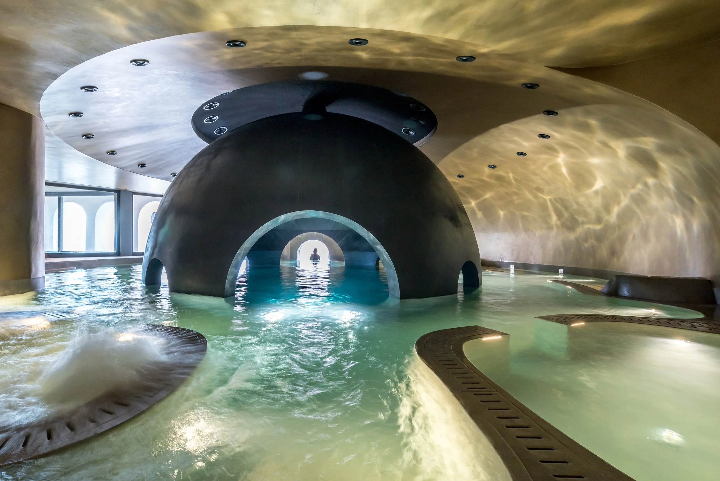 Spa de luxe en Grèce : piscine intérieure futuriste avec arches, espace de détente et de relaxation exclusive