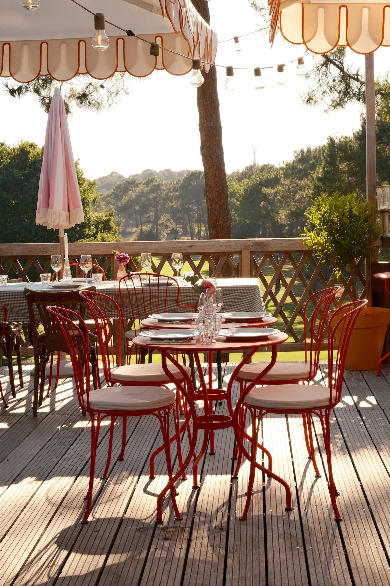 Tables dressées en terrasse bois avec vue sur le golf et la pinède landaise, retraite yoga doux Lacanau mai 2026