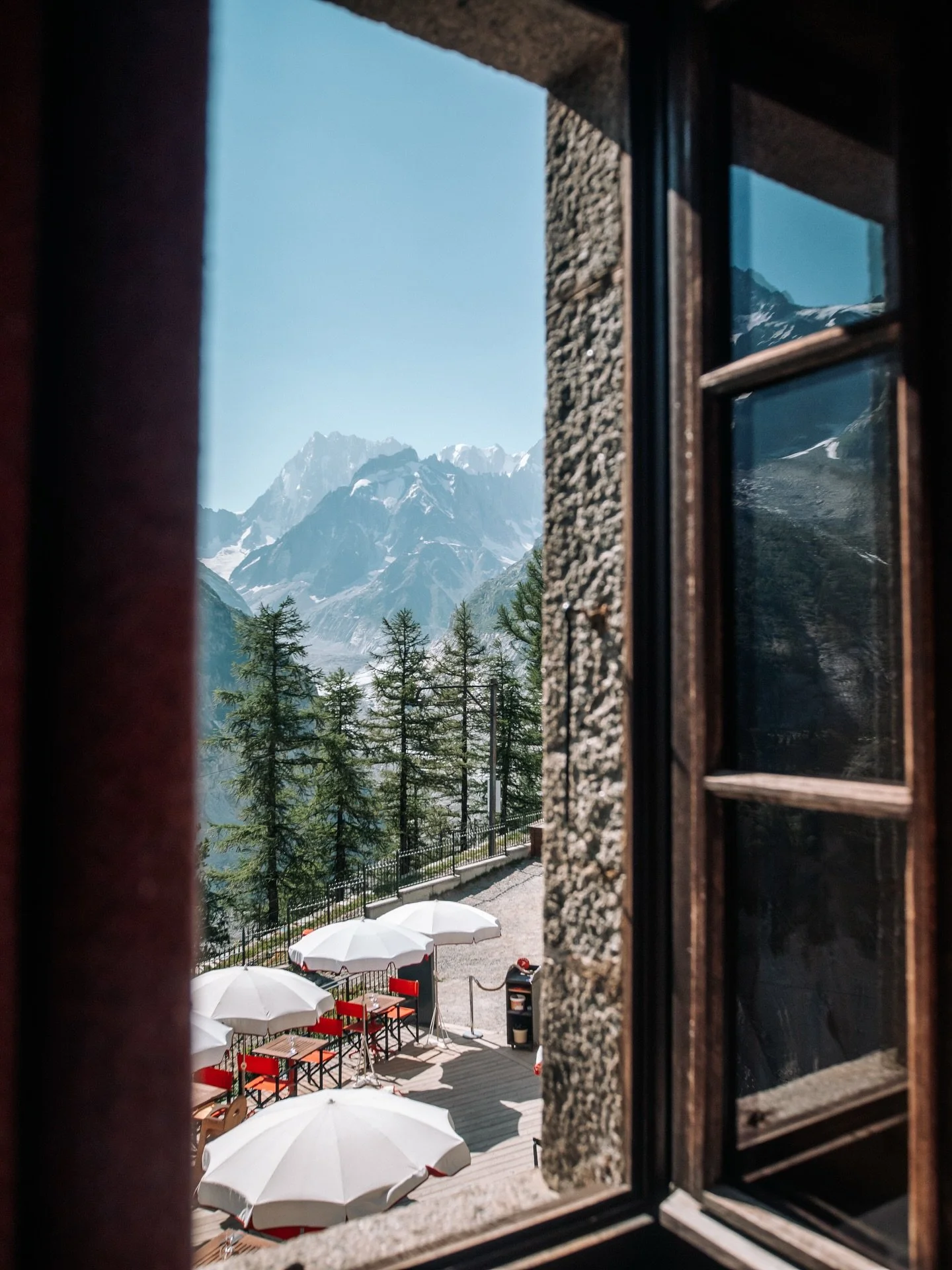 Instant suspendu depuis la fenêtre : vue majestueuse sur les sommets de Chamonix, cadre idéal pour méditer et ralentir, au refuge du Montenvers