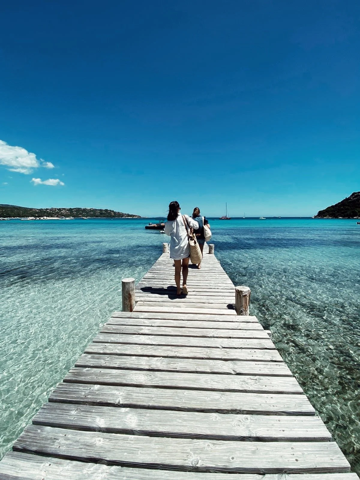 Expérience en mer au large des côtes corses : une participante profite d’une sortie en bateau, moment de liberté et de connexion à l’eau, dans le cadre de la retraite bien-être dédiée à l’apnée et à la danse sous-marine.