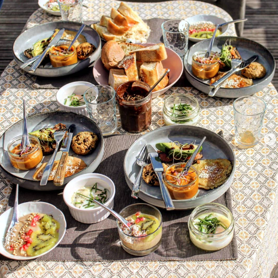 Table de brunch végétarien généreuse — chia pudding, fruits frais et salades colorées — pension complète gourmande lors d'une retraite yoga en France