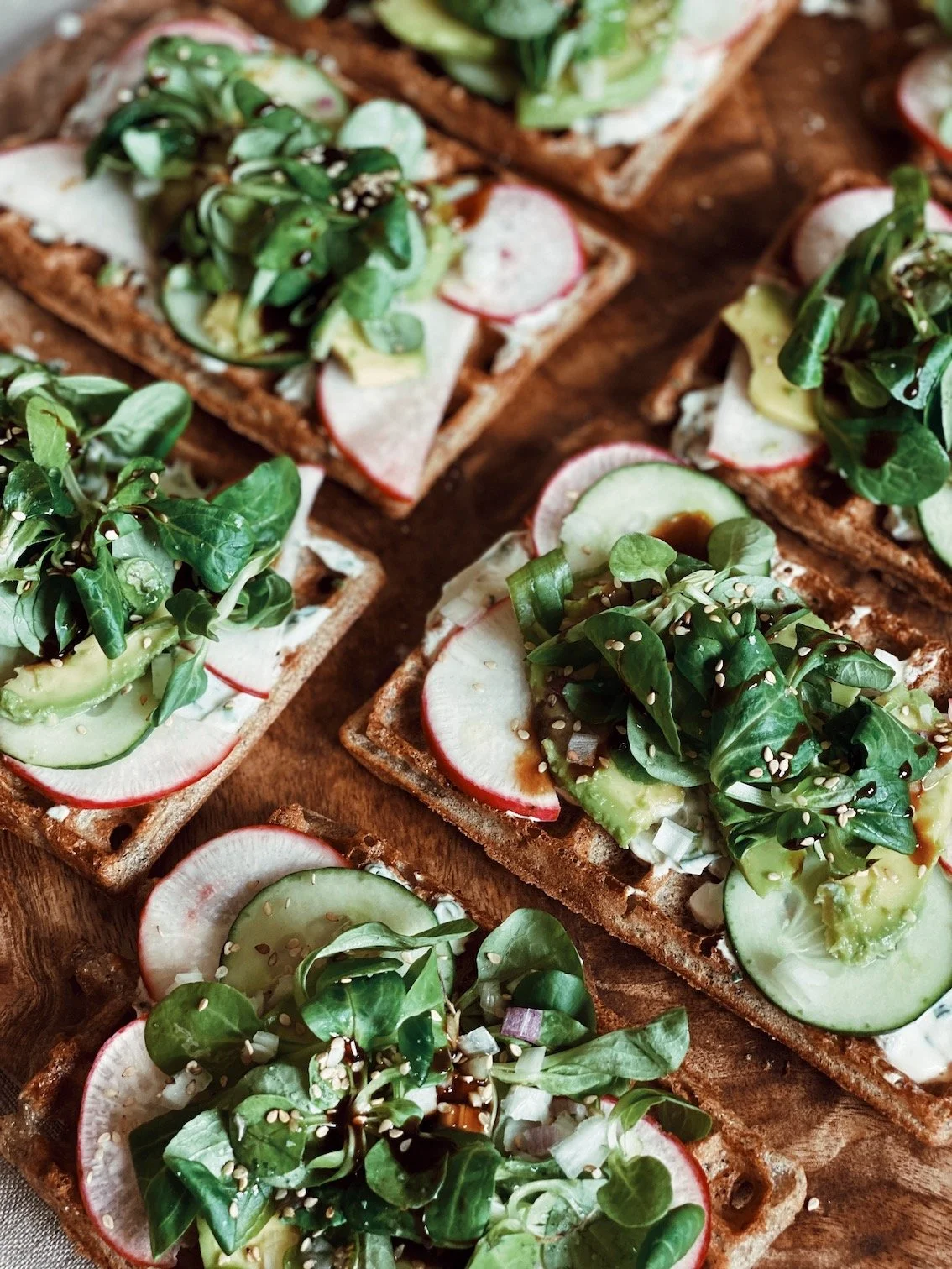 Assiette de toasts healthy garnis de légumes frais, radis et herbes aromatiques, servis pendant la retraite bien-être à Lacanau. Une cuisine végétarienne locale, saine et savoureuse.