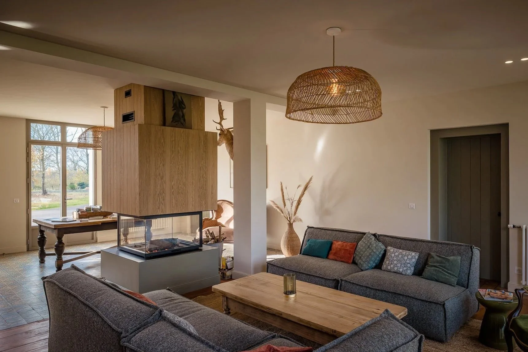 alon cosy et lumineux du domaine, canapés face à face et vue sur le jardin — cadre de ressourcement pour un séjour bien-être en Baie de Somme