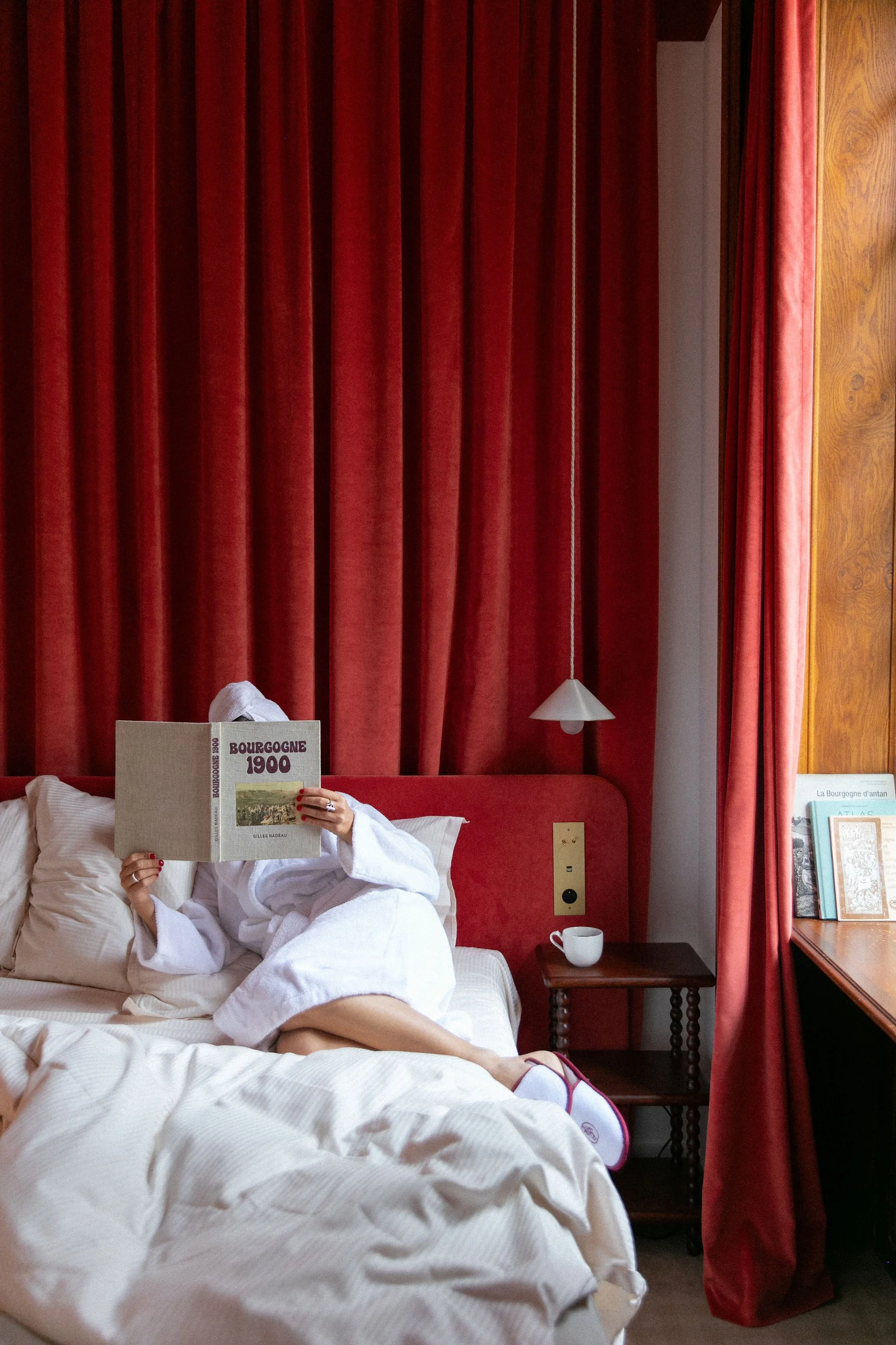 Lecture et détente dans la chambre à l’Hôtel Bellevigne, pendant une retraite yoga en Bourgogne. Week-end bien-être entre confort, nature et sérénité