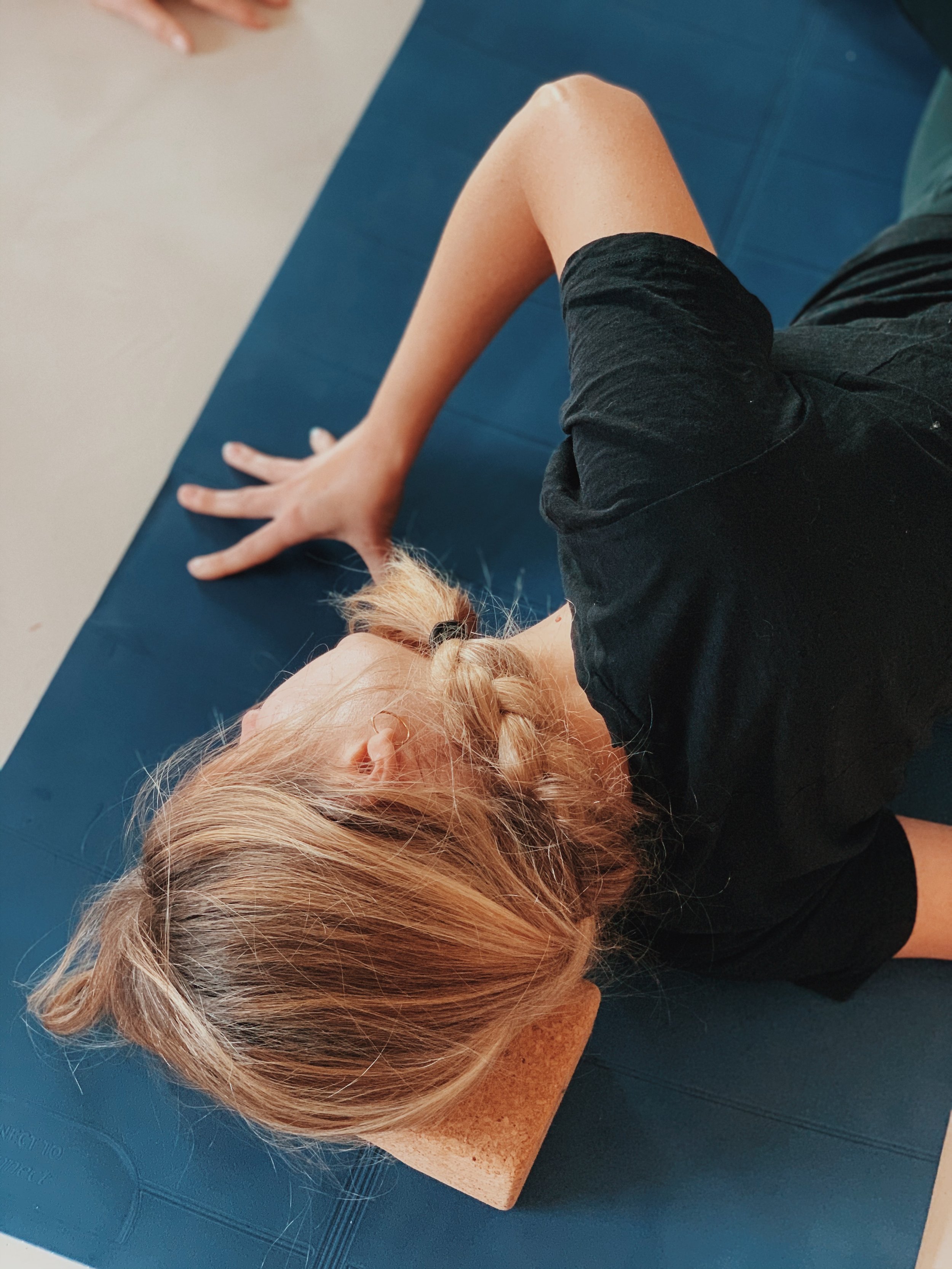 Posture de relâchement et d’étirement sur tapis pendant une retraite yoga et équitation dans le Sud-Ouest