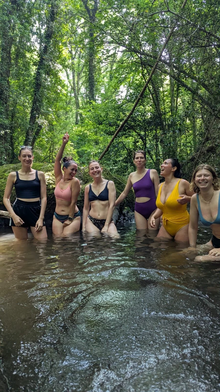 Immersion joyeuse dans une rivière fraîche, un rituel naturel et libérateur lors de la retraite yoga en pleine nature.