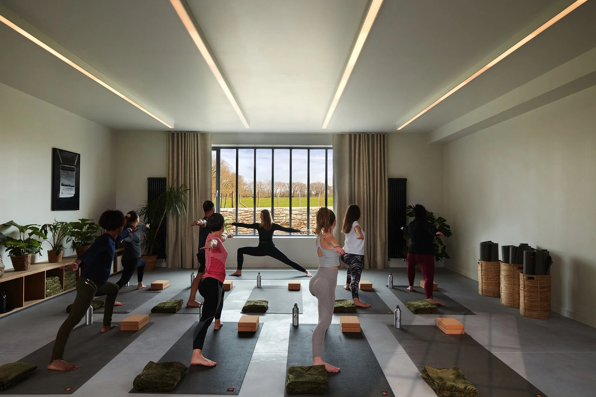 Group yoga practice bathed in natural light. A unique atmosphere for an upscale yoga & meditation getaway in Brittany.