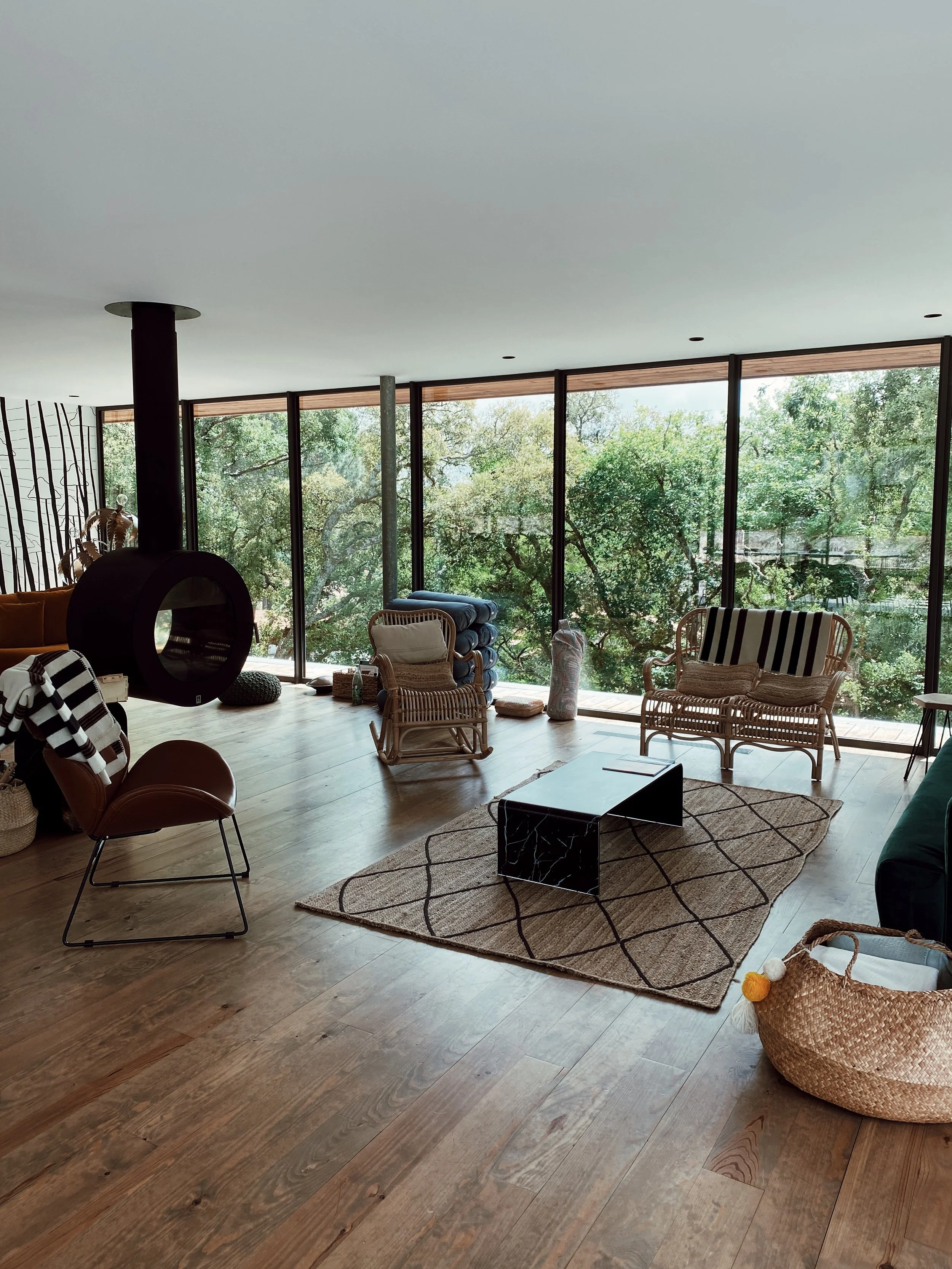Espace de détente lumineux avec vue sur la forêt, lieu idéal pour se ressourcer lors d’une retraite yoga et bien-être en pleine nature.