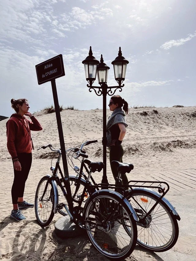 Deux personnes à vélo dans un paysage naturel ouvert, activité plein air retraite yoga nouvel an original Landes

