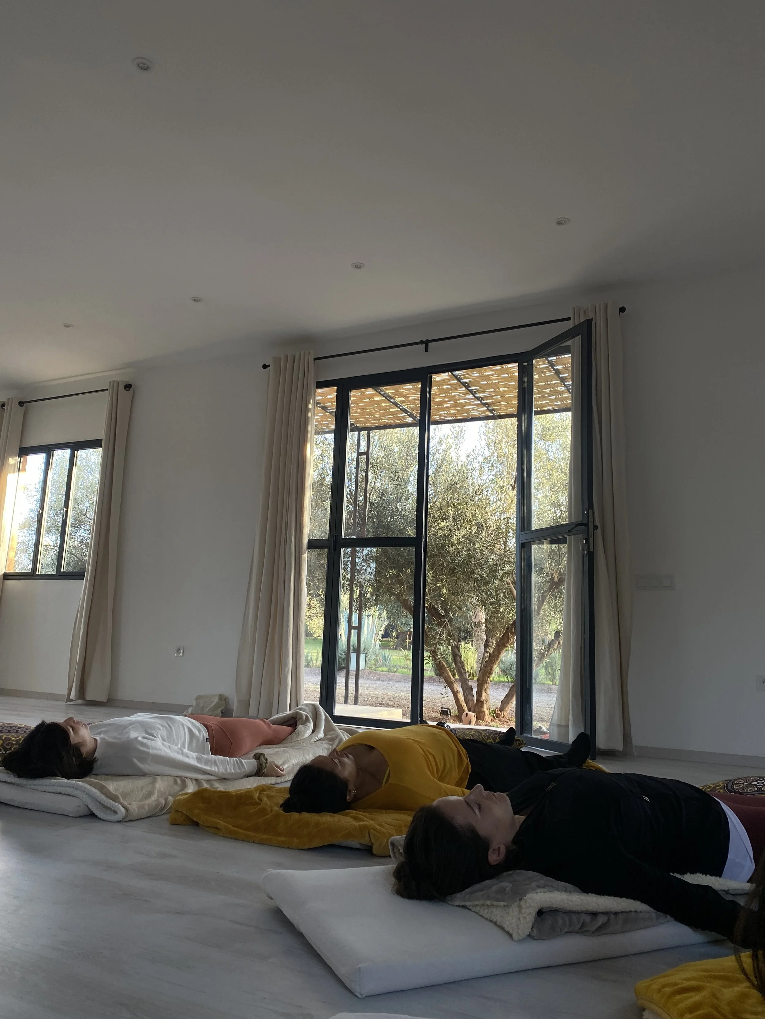 Salle de yoga lumineuse avec vue sur le jardin — cours Hatha Flow et Yin yoga retraite Marrakech 2026