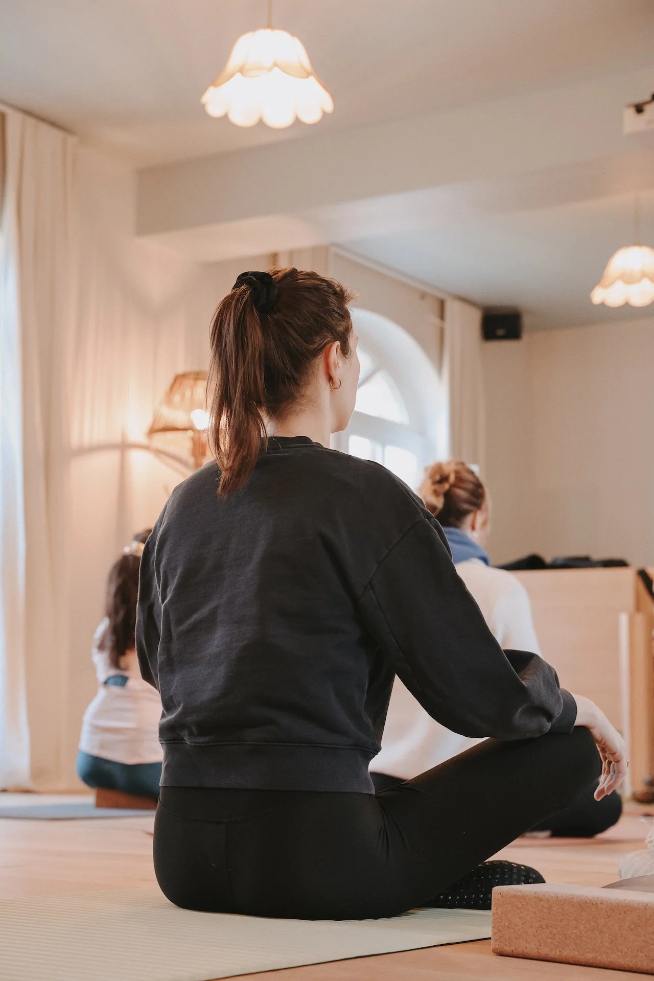 Participantes de dos en position de méditation assise lors d'un cours de yoga — retraite yoga massage et bien-être en Baie de Somme