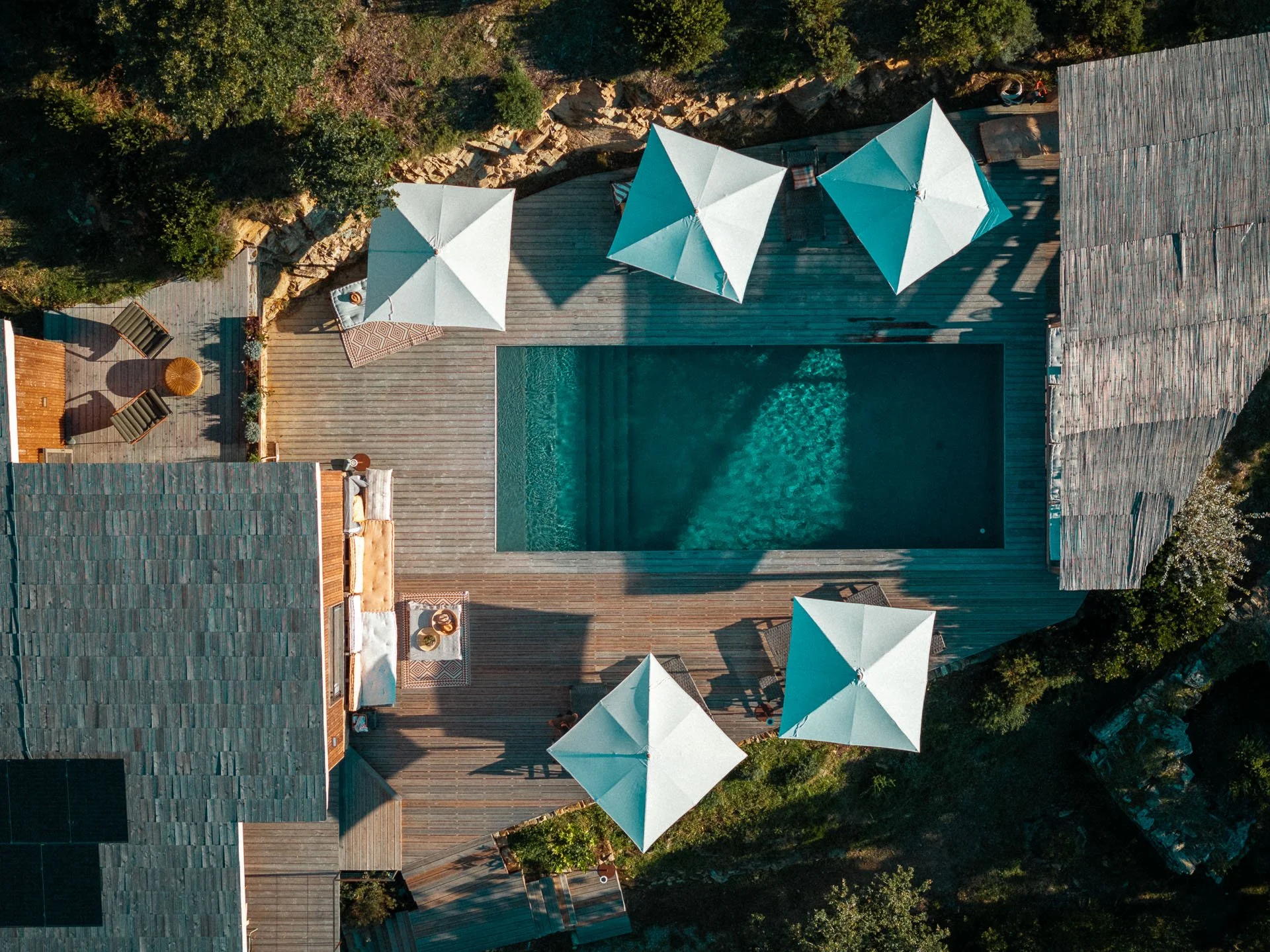 piscine vue du ciel, s’intégrant dans le paysage corse entre maquis et Méditerranée, symbole de calme et d’harmonie pendant la retraite yoga