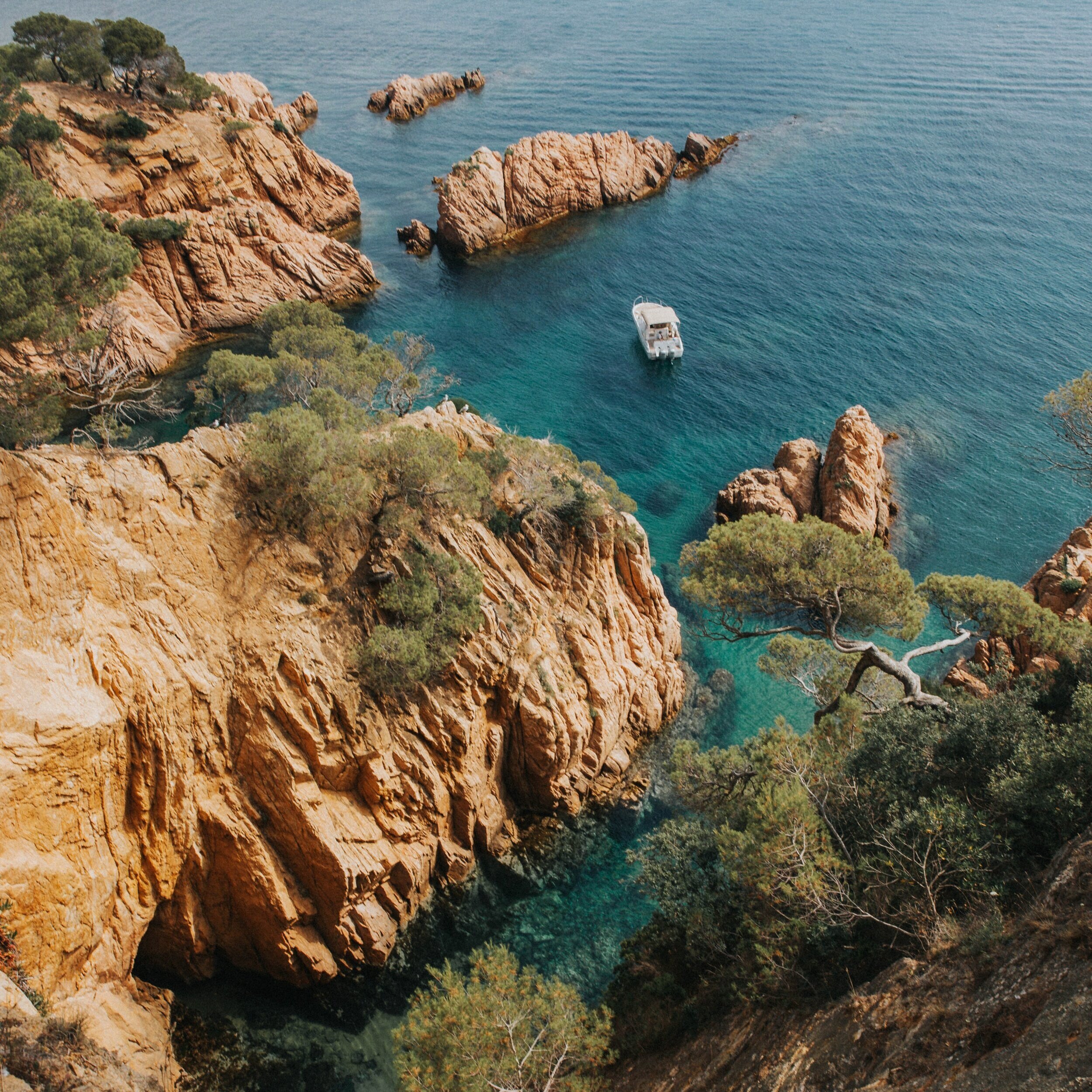 Paysage côtier d’Ibiza avec rochers et mer turquoise, cadre naturel pour une retraite yoga et pilates