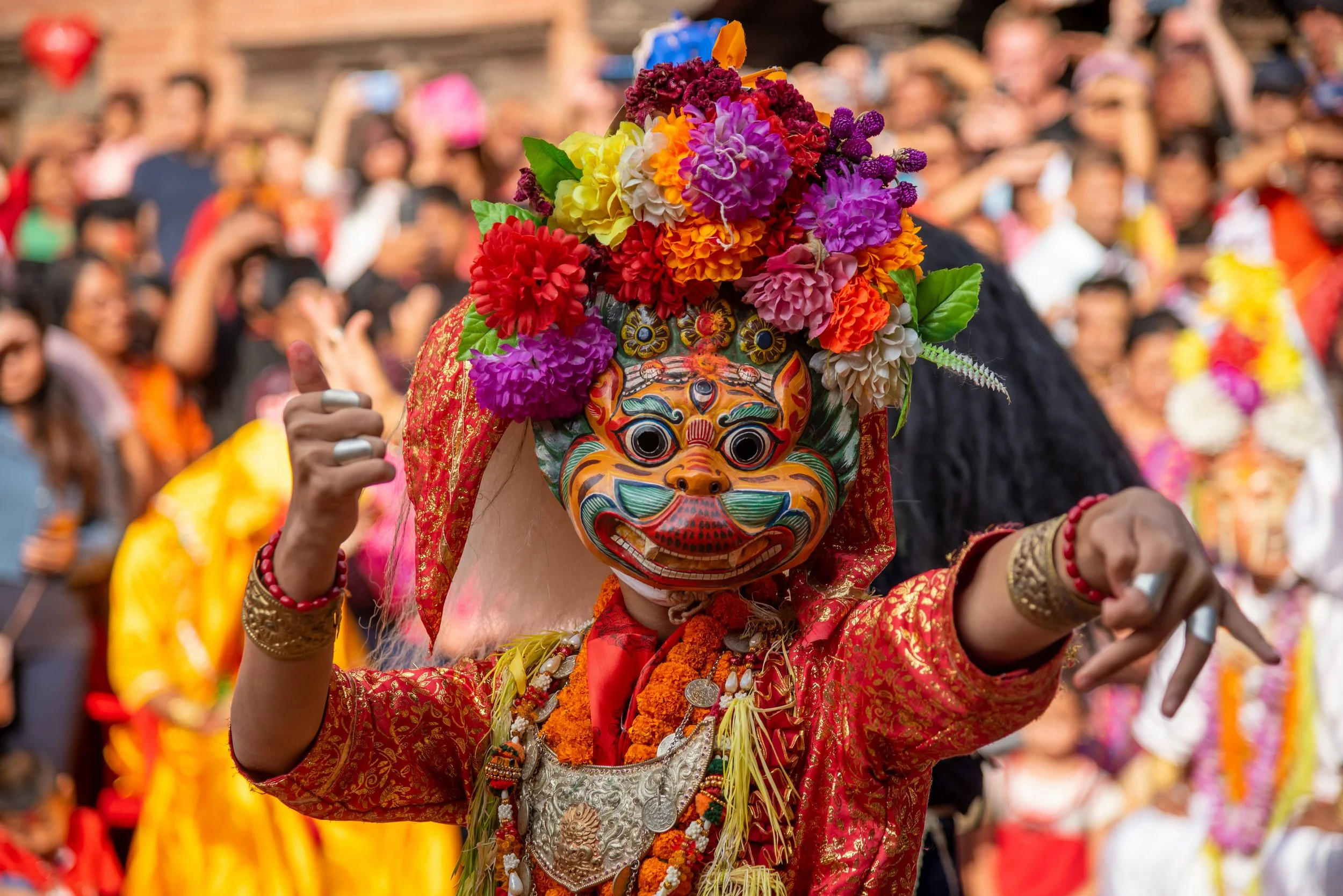 Danseur masqué en costume traditionnel fleuri lors d'une fête religieuse au Népal — immersion culturelle au cœur de Katmandou