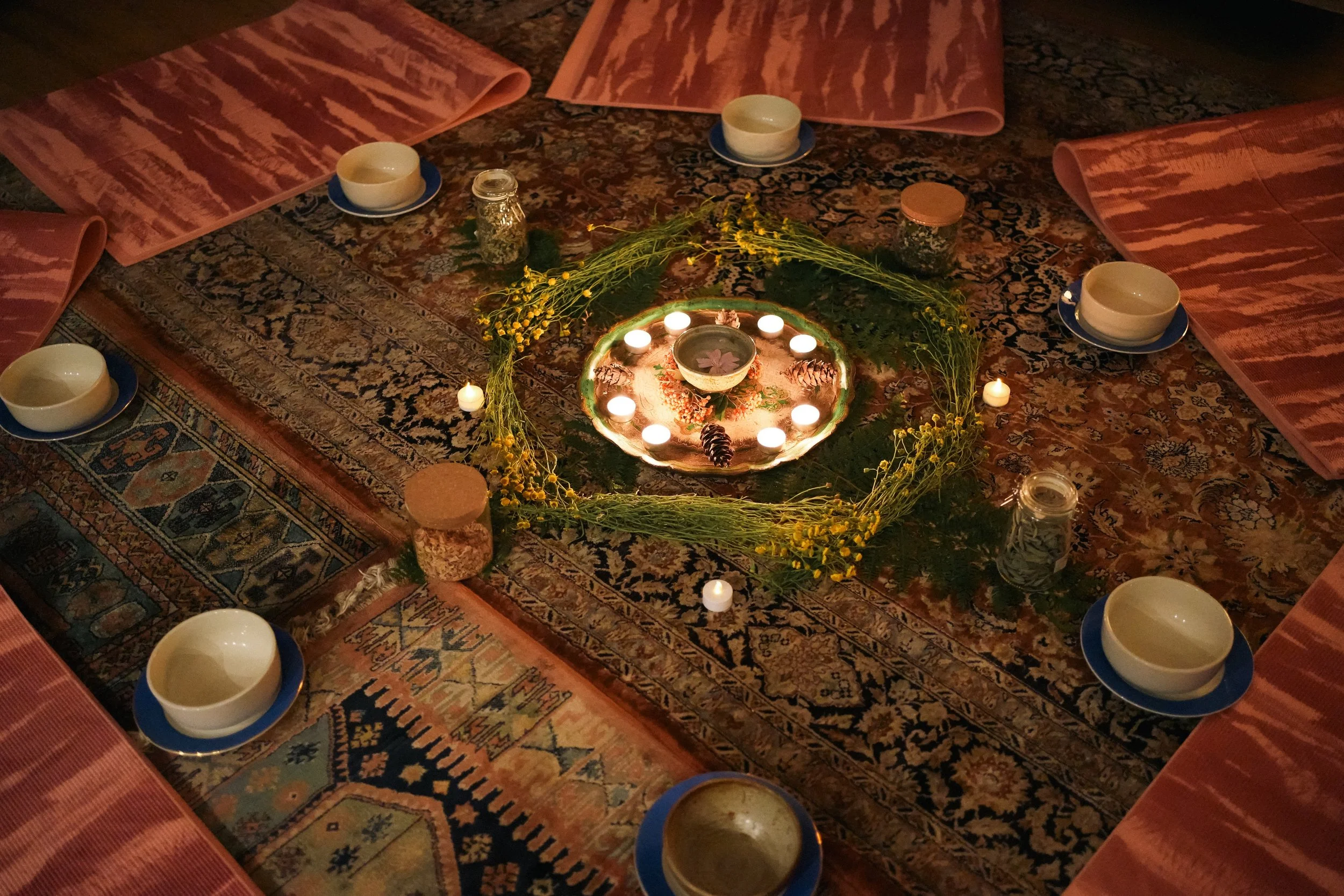 Cercle sacré en intérieur avec bougies et intentions, moment de connexion profonde pendant la retraite yoga au féminin.