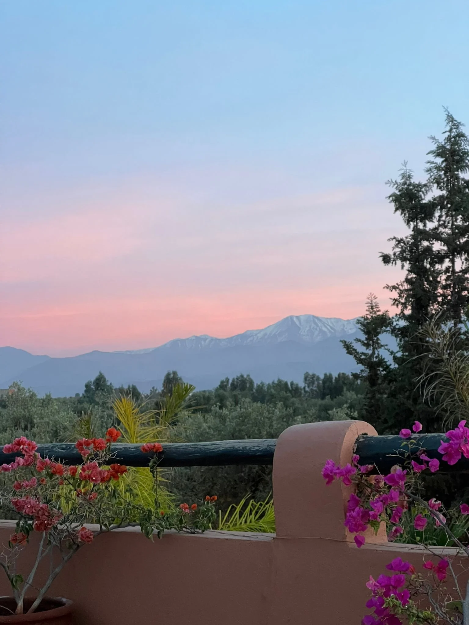 Vue sur l'Atlas enneigé au coucher du soleil depuis le riad — retraite yoga arrière-pays Marrakech Maroc