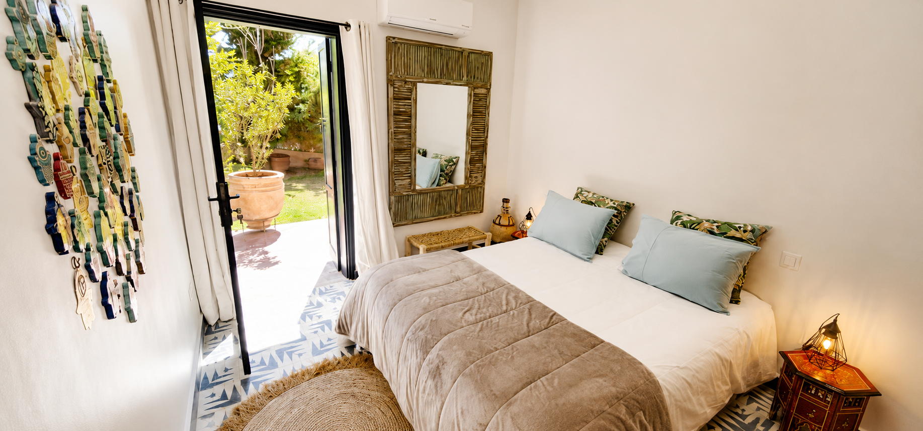 Chambre double lumineuse avec miroir en bois et vue sur jardin — hébergement riad retraite yoga Marrakech Maroc