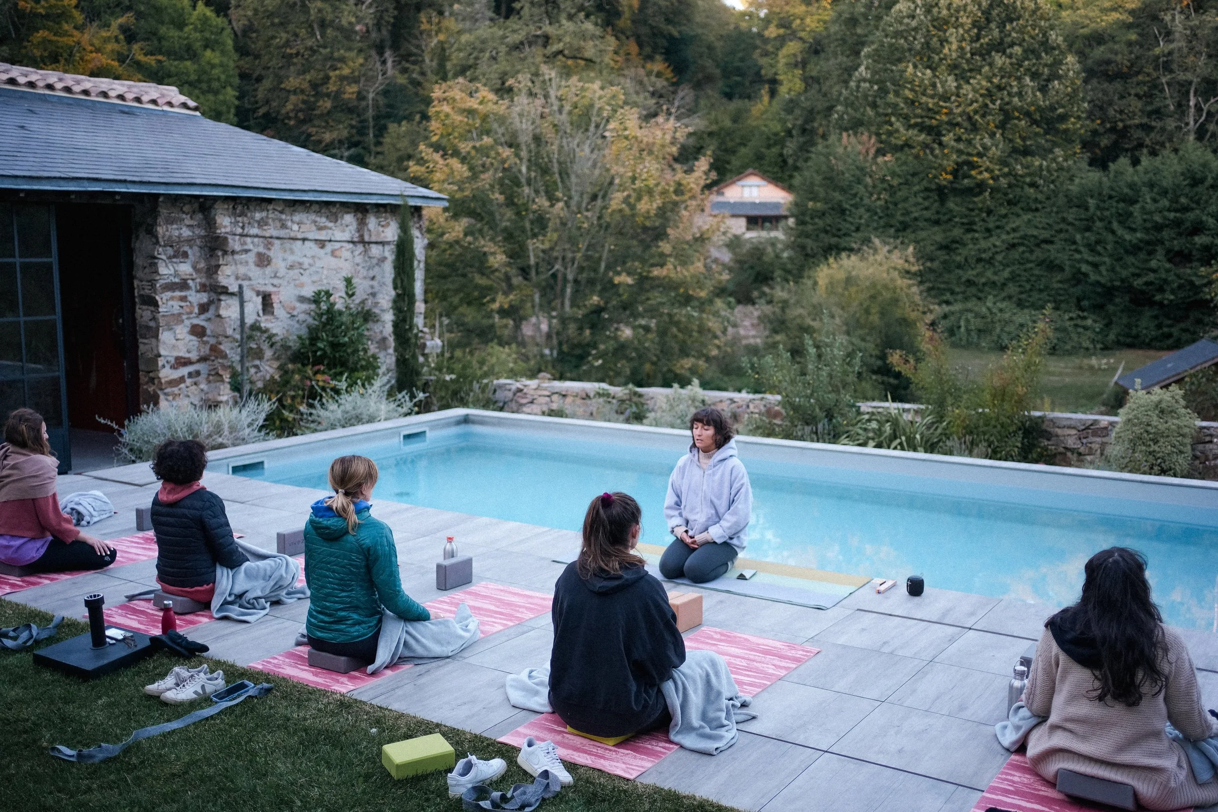 Pratique de yoga en extérieur près de la piscine lors de notre retraite yoga & céramique en Bourgogne, une parenthèse estivale ressourçante.