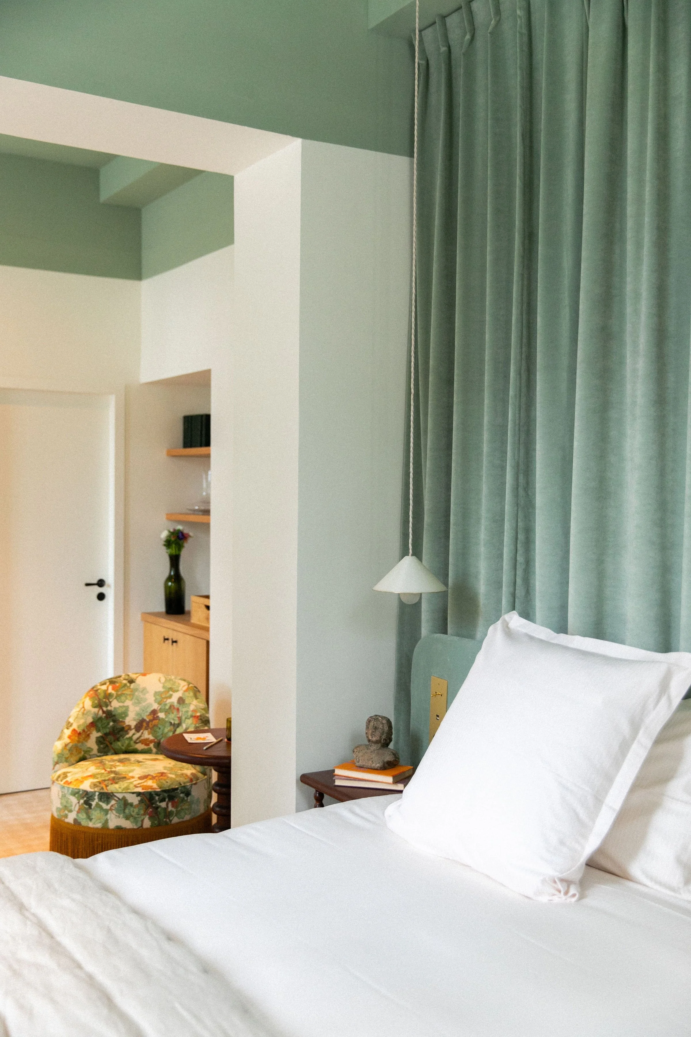 Chambre apaisante avec fauteuil fleuri à l’Hôtel Bellevigne, hébergement élégant pour une retraite yoga, nature et détente au cœur du vignoble bourguignon.