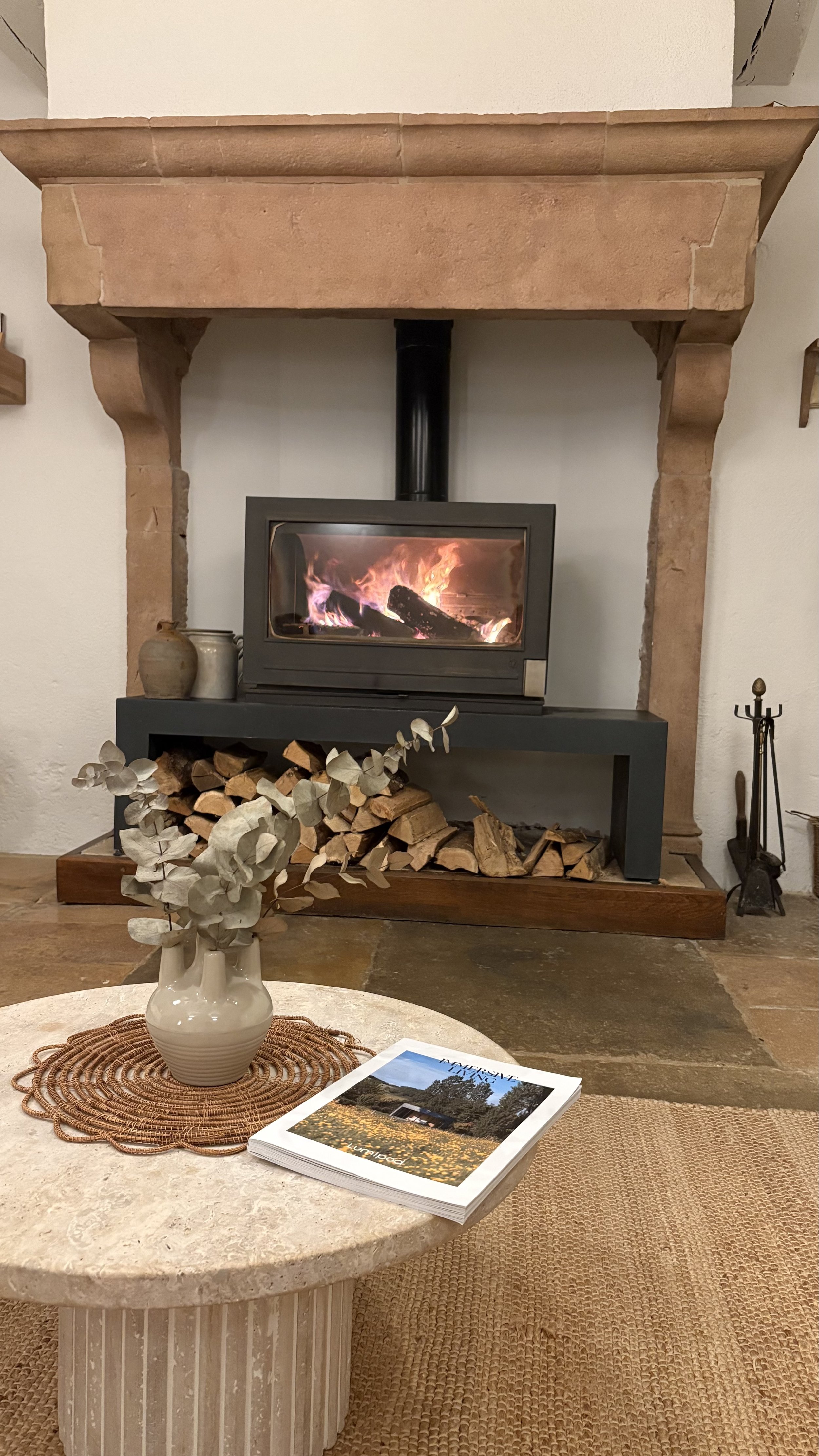 Salon avec cheminée allumée et fleurs séchées — ambiance cocooning retraite yoga automne Bourgogne