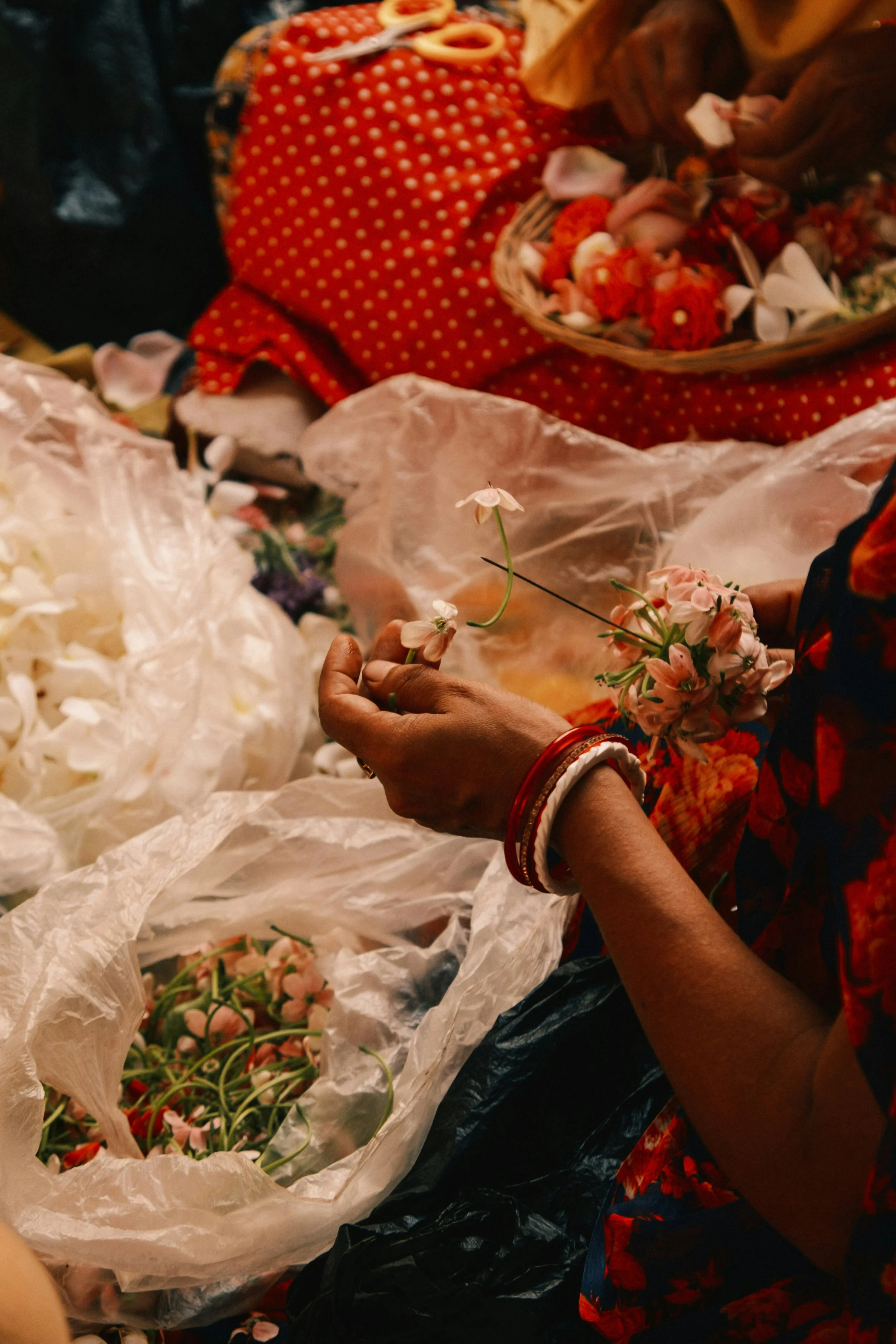 Des mains de femmes plongées dans des fleurs séchées évoquent la douceur d’une retraite yoga en Inde, entre voyage spirituel, immersion en ashram et pratiques méditatives inspirées de l’ayurveda et des traditions indiennes.