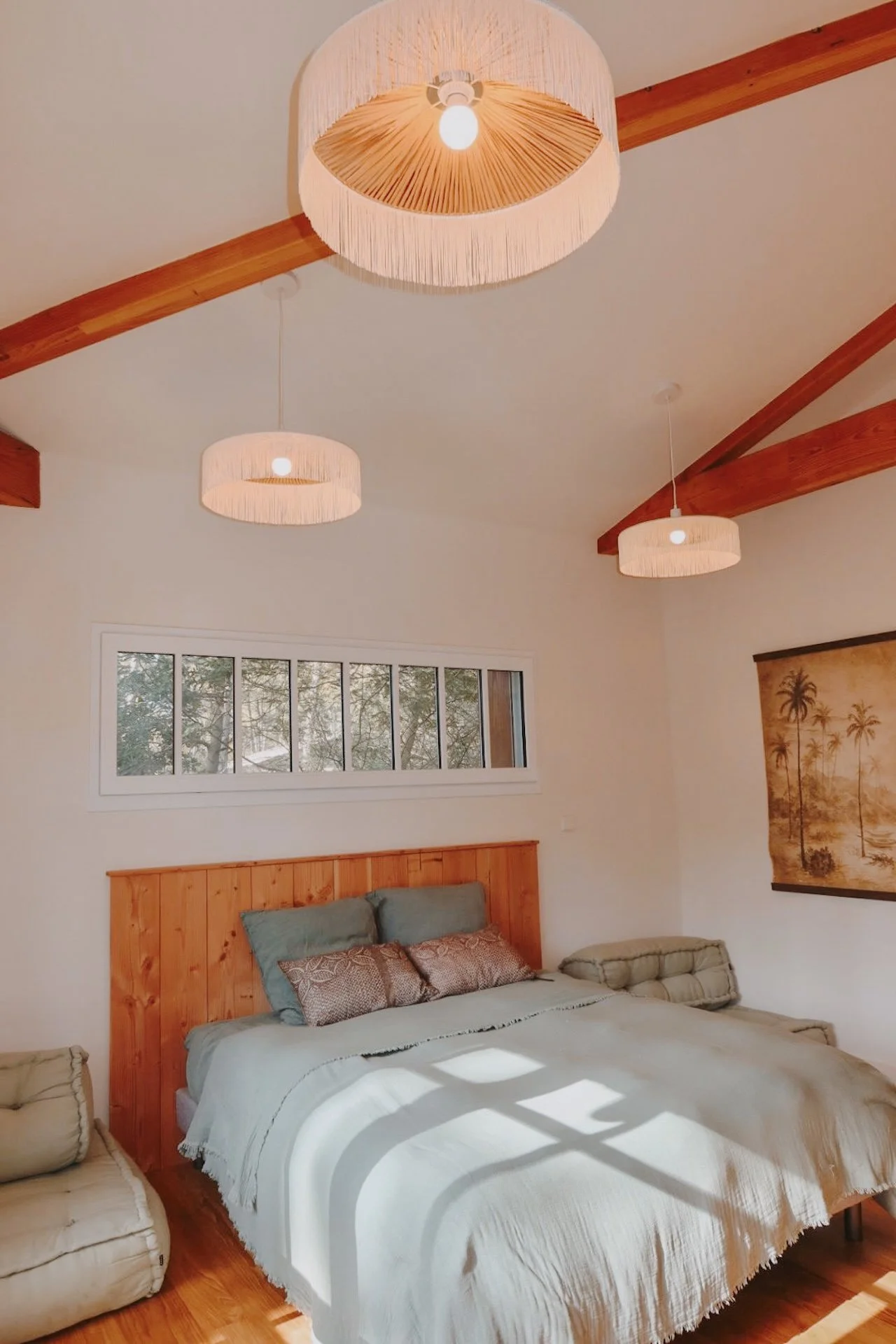 Chambre twin supérieure aux poutres apparentes et fenêtre sur la forêt de pins — atmosphère cosy d'une maison d'exception au Cap Ferret