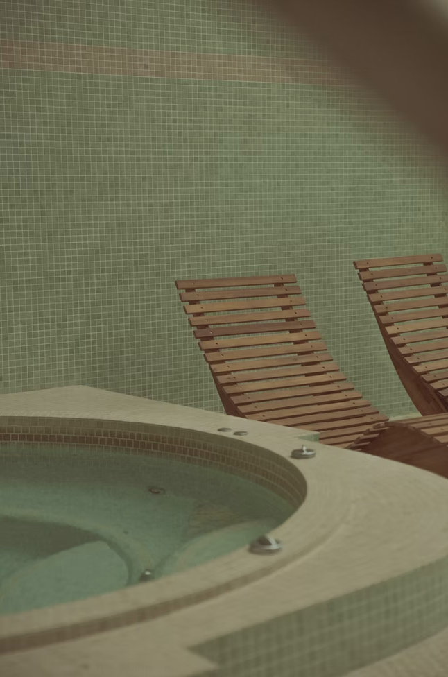 Détail carrelage vintage vert et transats en bois au bord de la piscine, hôtel La Baignoire Lacanau