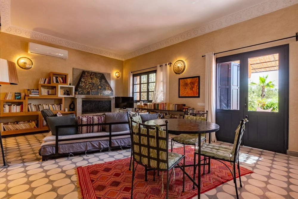 Salon intérieur avec tapis berbère et décor marocain traditionnel — hébergement authentique retraite yoga Marrakech