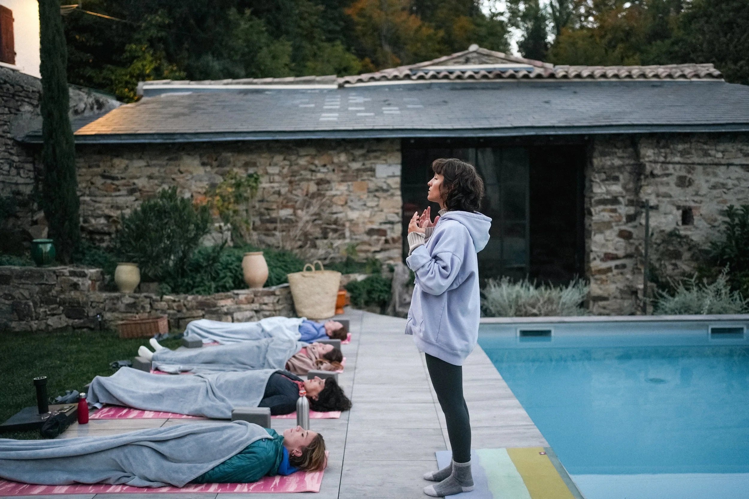 Moment de détente guidée près de la piscine après une pratique de yoga, lors d’un séjour bien-être en pleine nature dans le sud