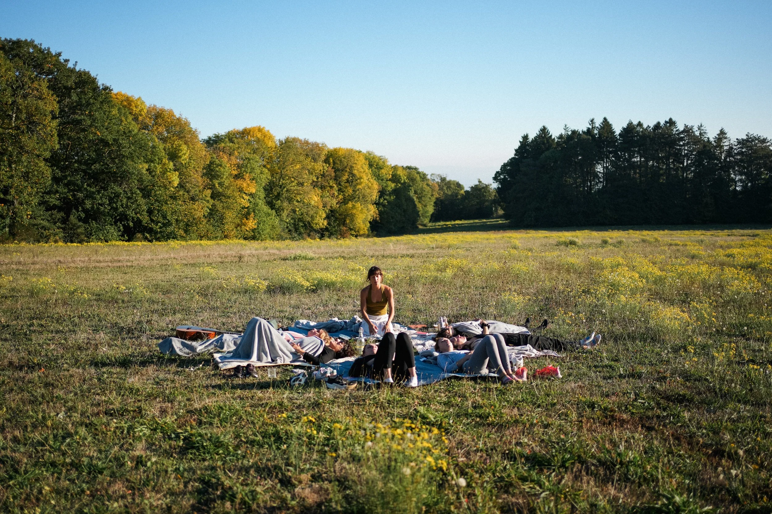 Moment de détente en groupe allongé dans la nature - séjour bien-être et reconnexion