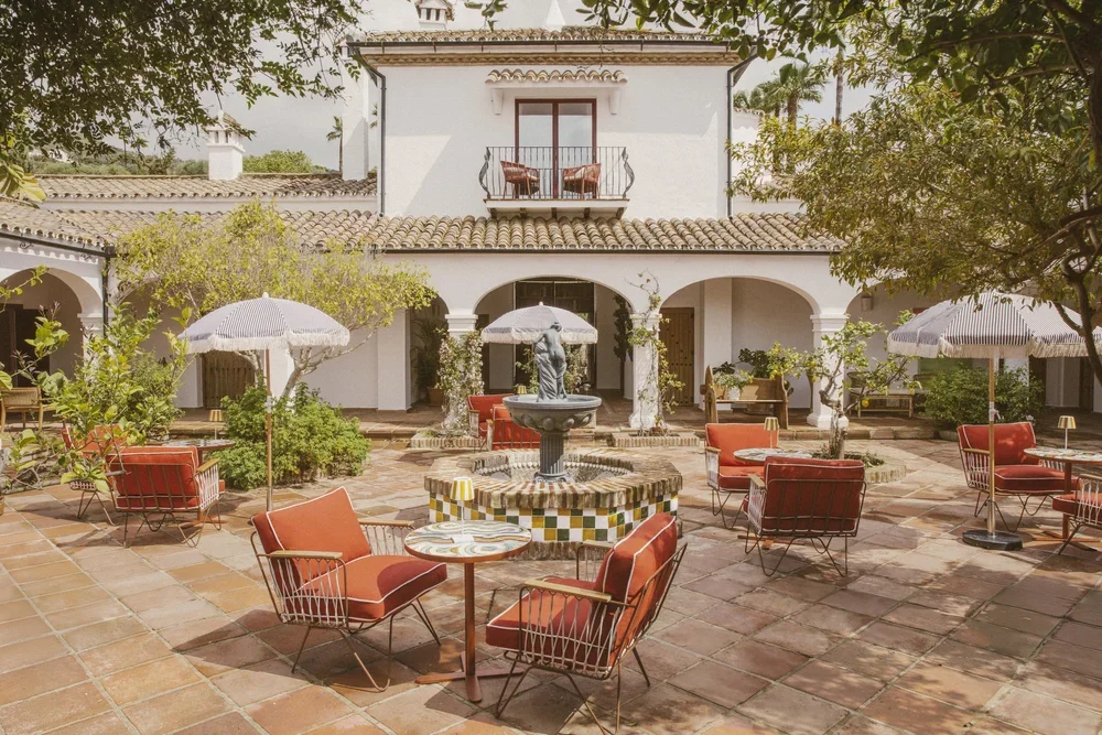Patio andalou avec fontaine et arcades blanches — cadre authentique retraite yoga bien-être Espagne 2026