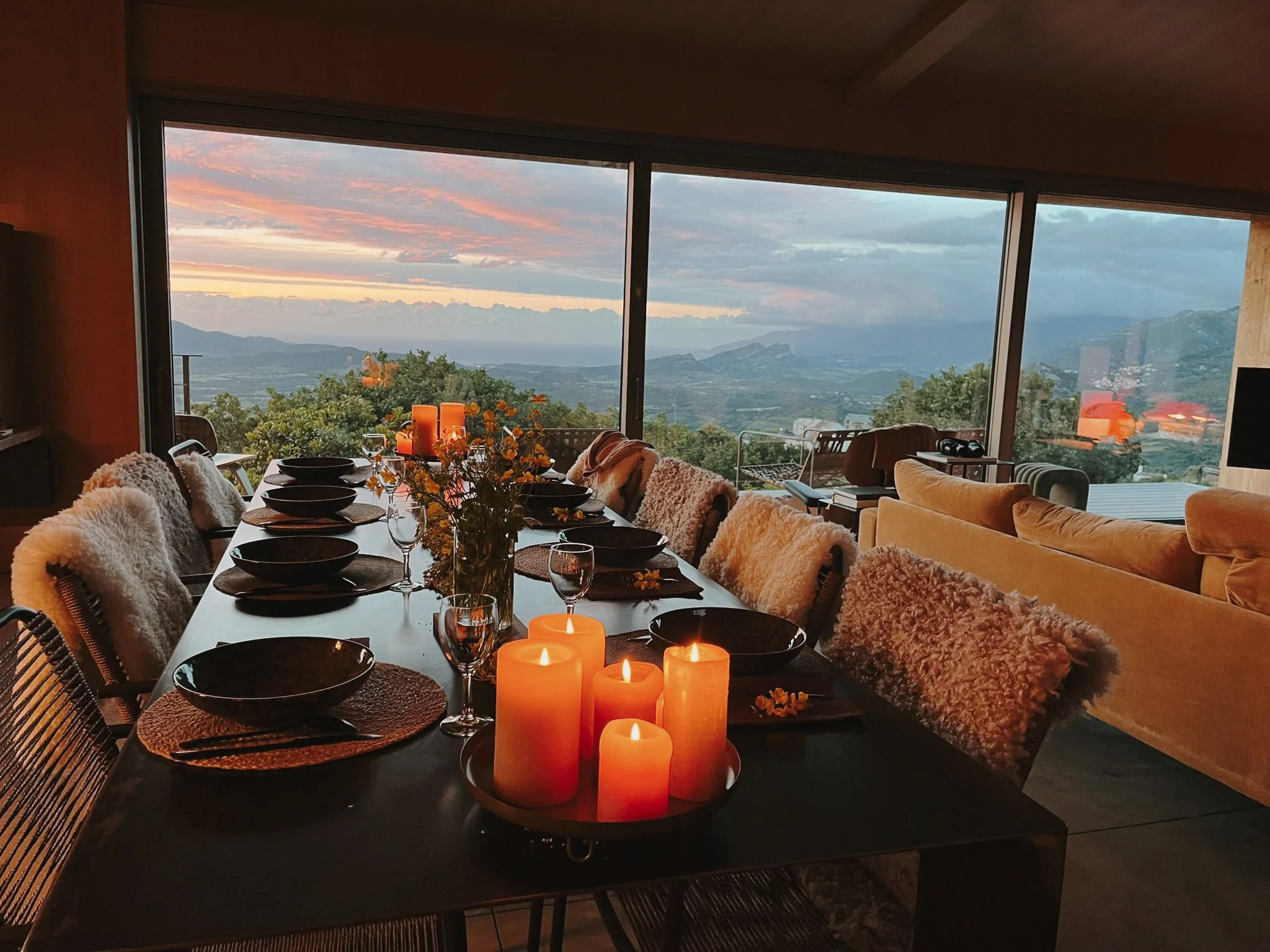 Table dressée aux chandelles avec vue panoramique sur les montagnes corses au coucher du soleil — dîner retraite yoga sororité Haute-Corse automne 2026