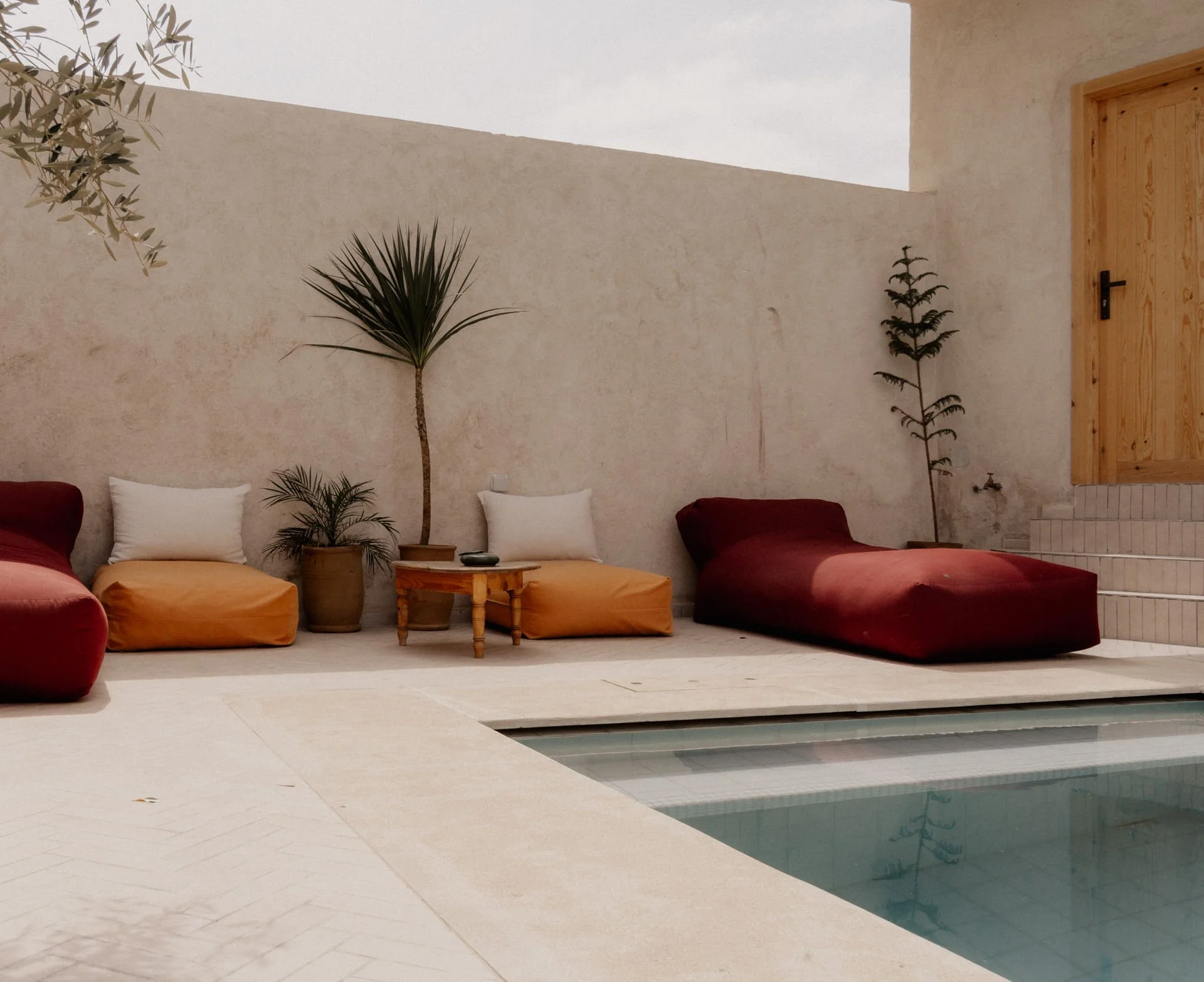 Salon cosy avec piscine intérieure et coussins colorés - maison d'hôtes retraite yoga Maroc